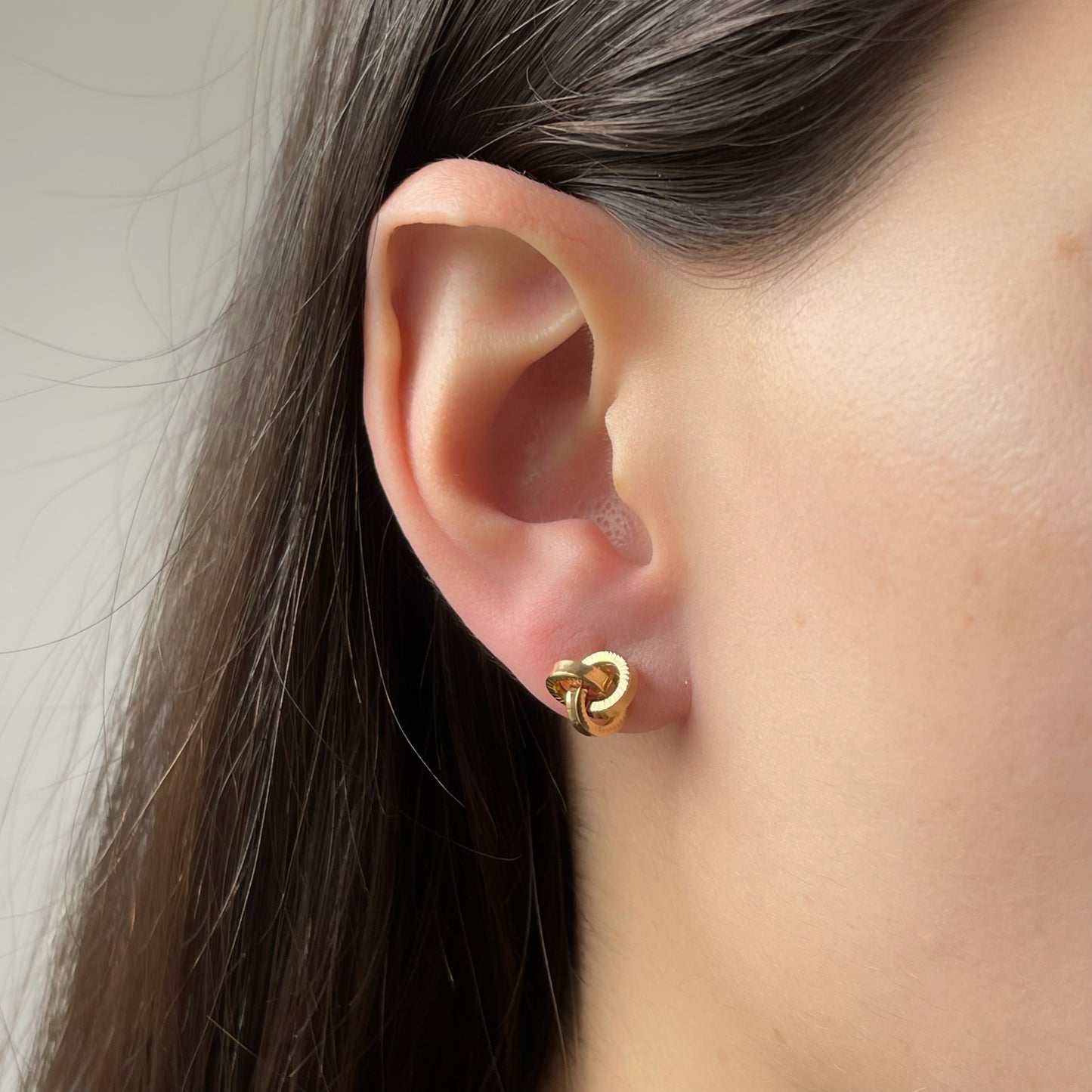 Aretes de nudo de oro amarillo 18k con aros planos con textura