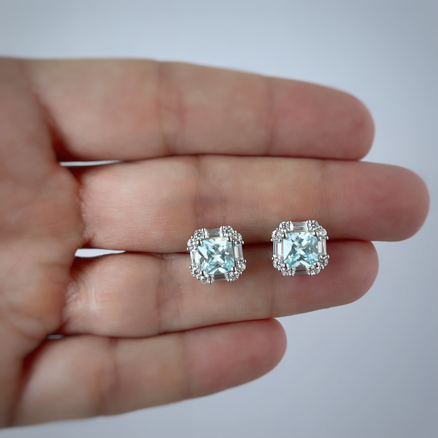 Arete de plata con baño platino cuadrado y circonita aquamarina con halo de circonitas blancas