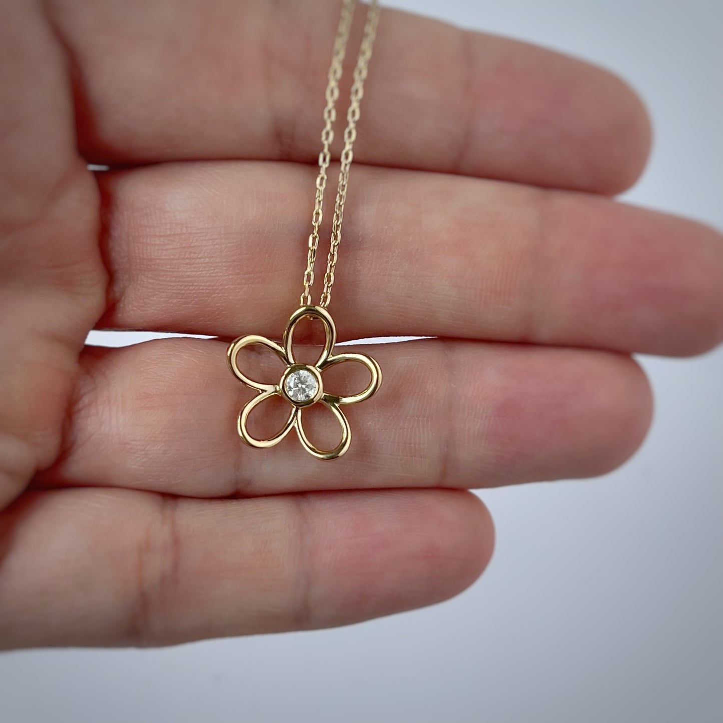 Collar en plata con baño de oro amarillo con dije de flor delineada y diamante central 0.10ct