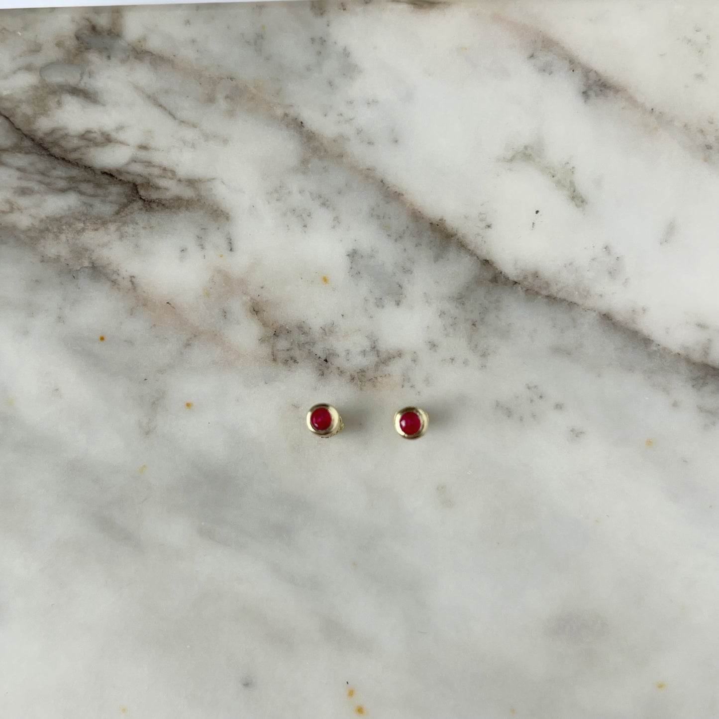 Aretes en oro amarillo 14k con circón biselado rojo con broche rosca