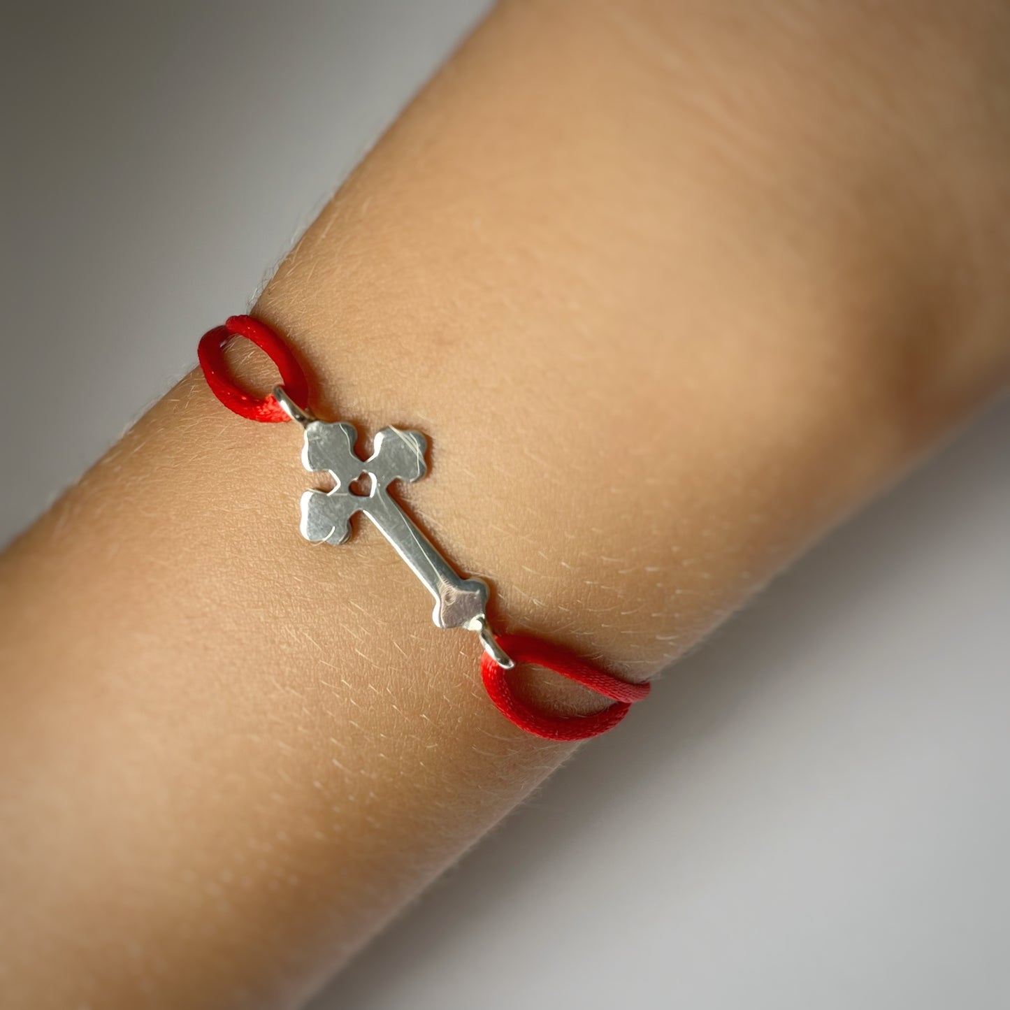 Pulsera de cordón con cruz de plata y corazoncito calado