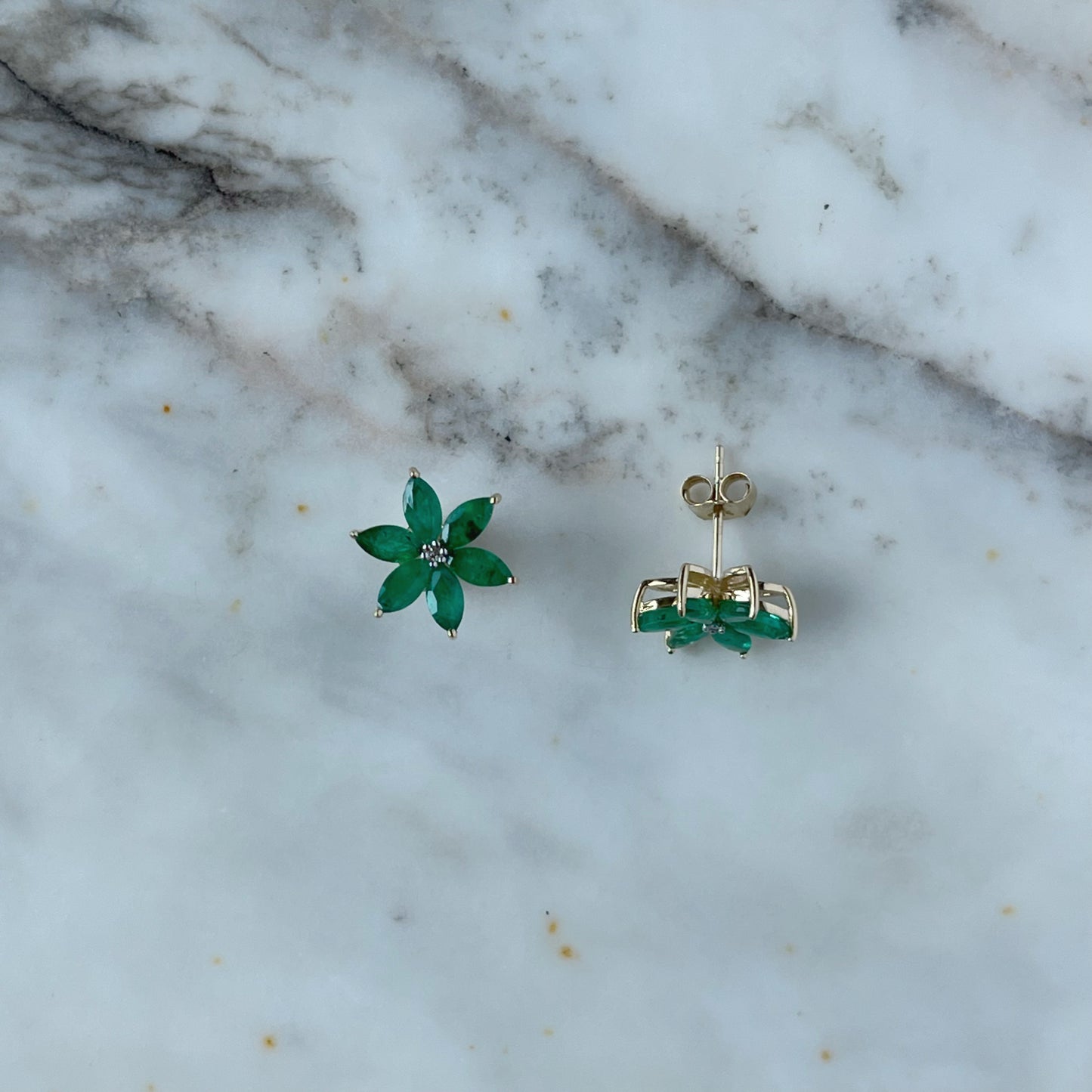 Aretes de flor de seis pétalos en oro amarillo 10K con esmeraldas y diamantes