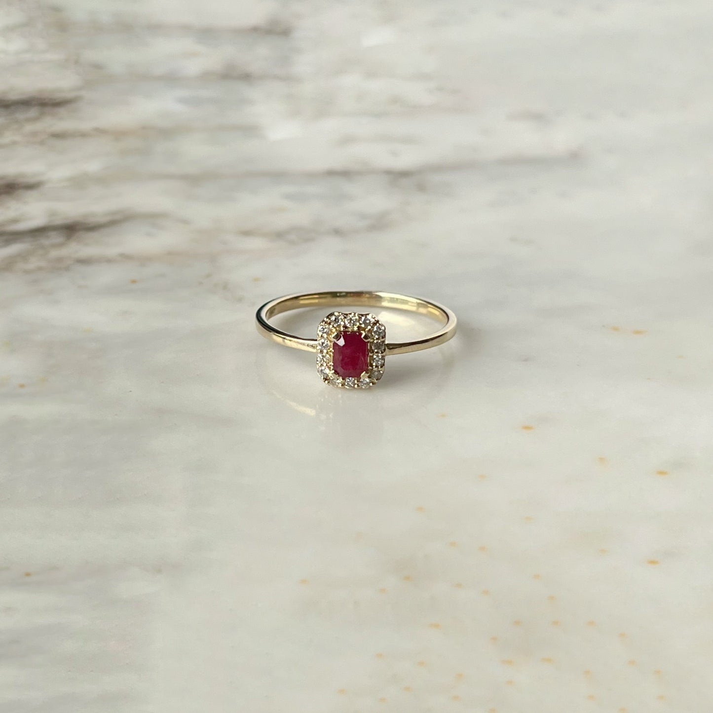 Anillo en oro amarillo 14k con rubí rectangular y halo de diamantes 0.10ctw
