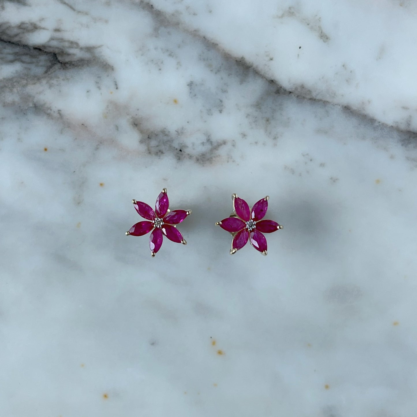 Aretes de flor de seis pétalos en oro amarillo 10K con rubíes y diamantes