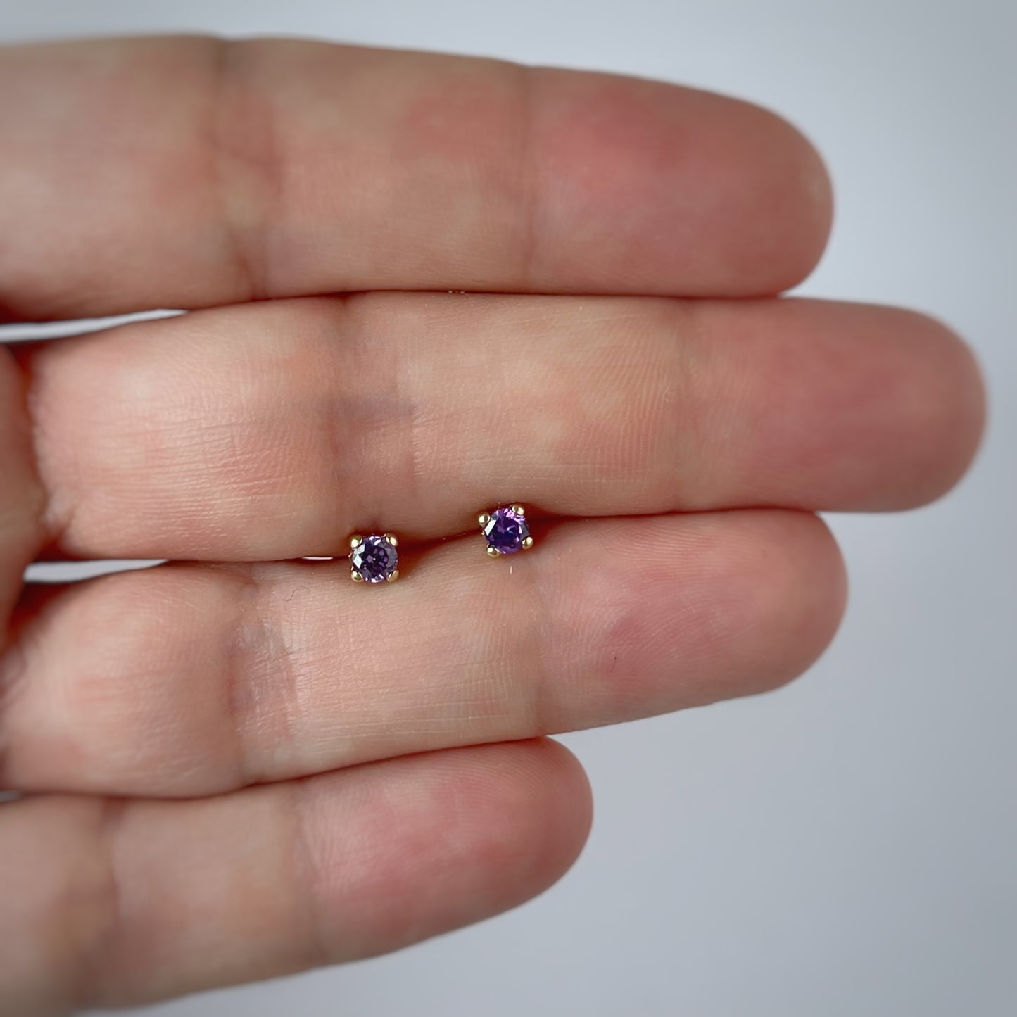 Aretes en oro amarillo 14k con circonita morada con broche rosca
