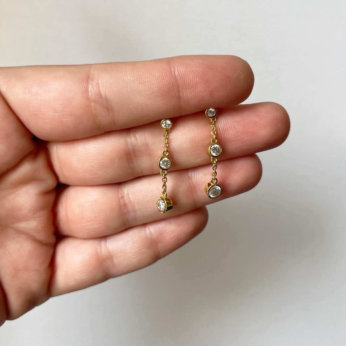 Aretes de plata con baño de oro amarillo y tres diamantes de laboratorio 1ctw