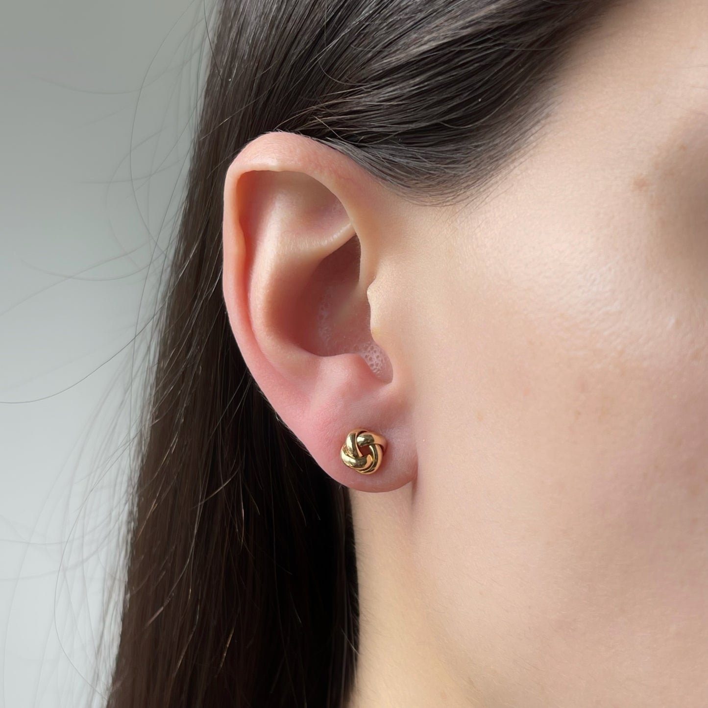 Aretes en oro amarillo 18 K de nudo de aros redondeados con tope tornillo