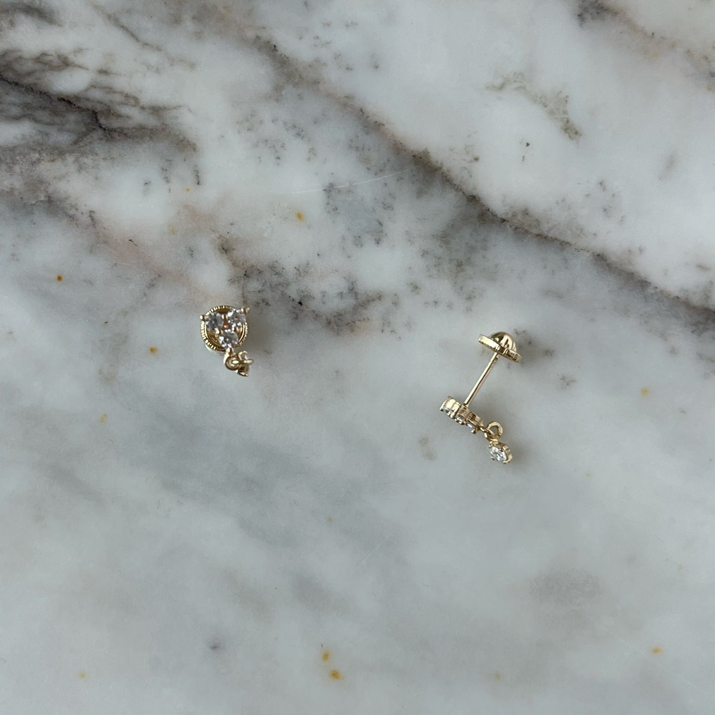 Arete single con tres circonitas blancas y una circonita colgante en oro amarillo de 14K con tope rosca