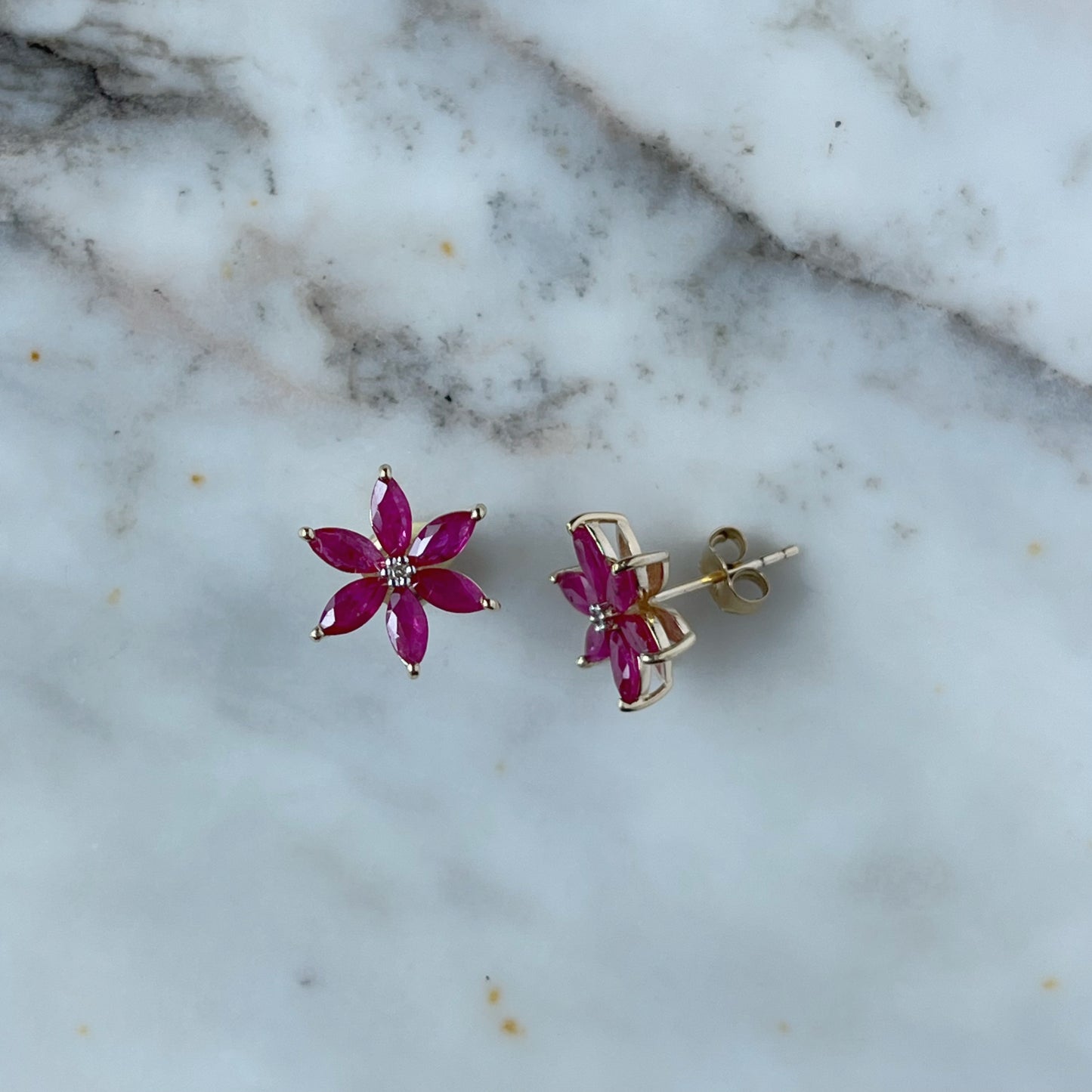 Aretes de flor de seis pétalos en oro amarillo 10K con rubíes y diamantes