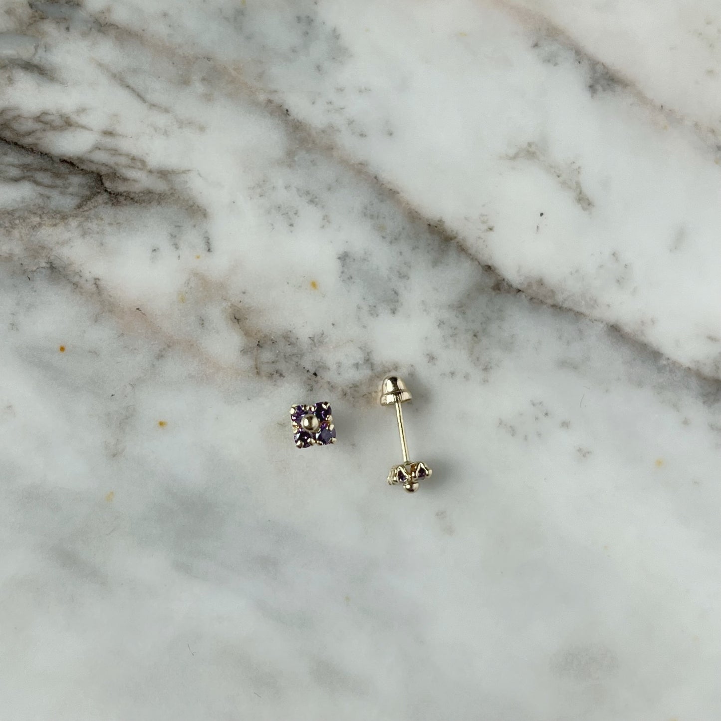 Aretes en oro amarillo 14k flores de circonitas morado con bolita de oro en el centro con broche rosca