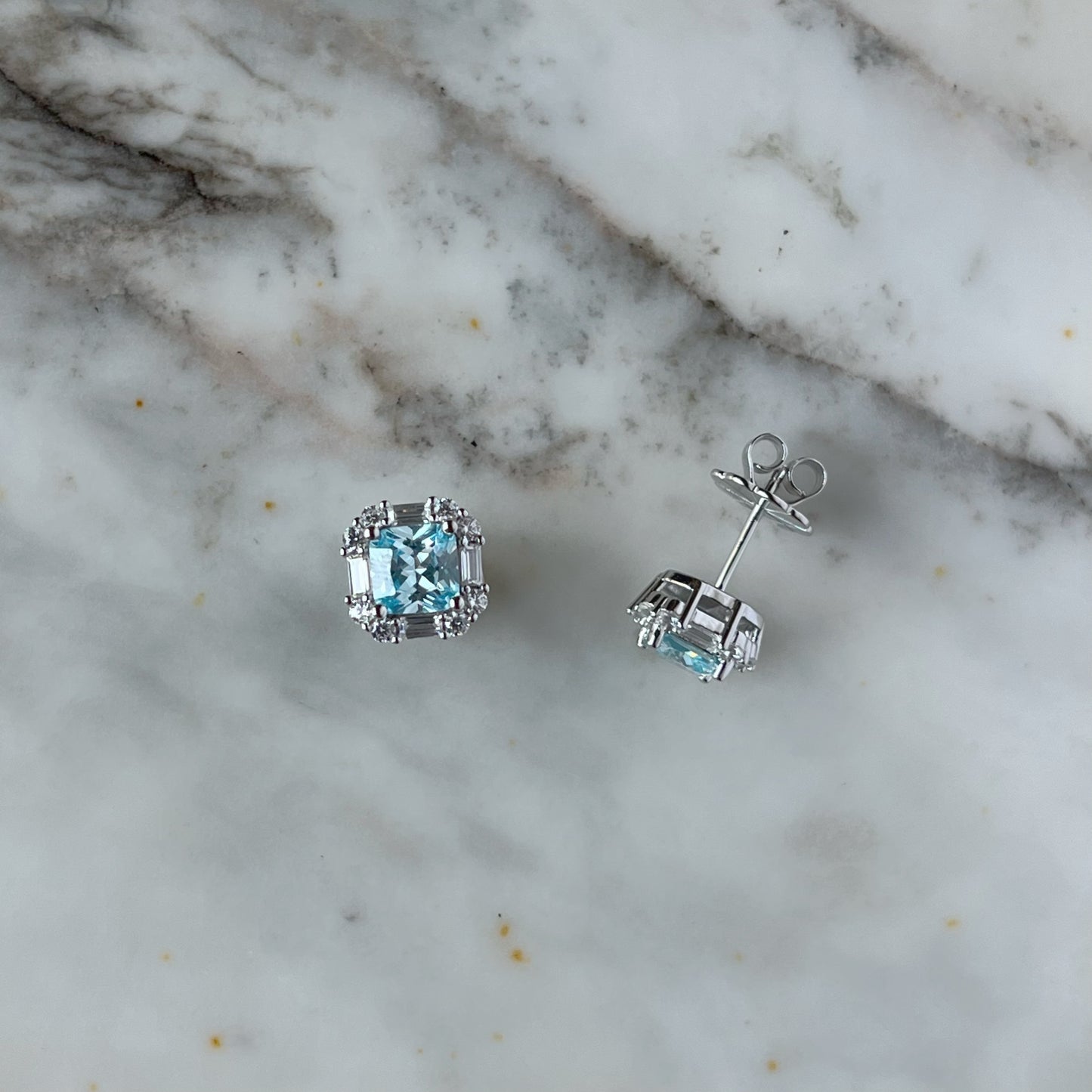 Arete de plata con baño platino cuadrado y circonita aquamarina con halo de circonitas blancas