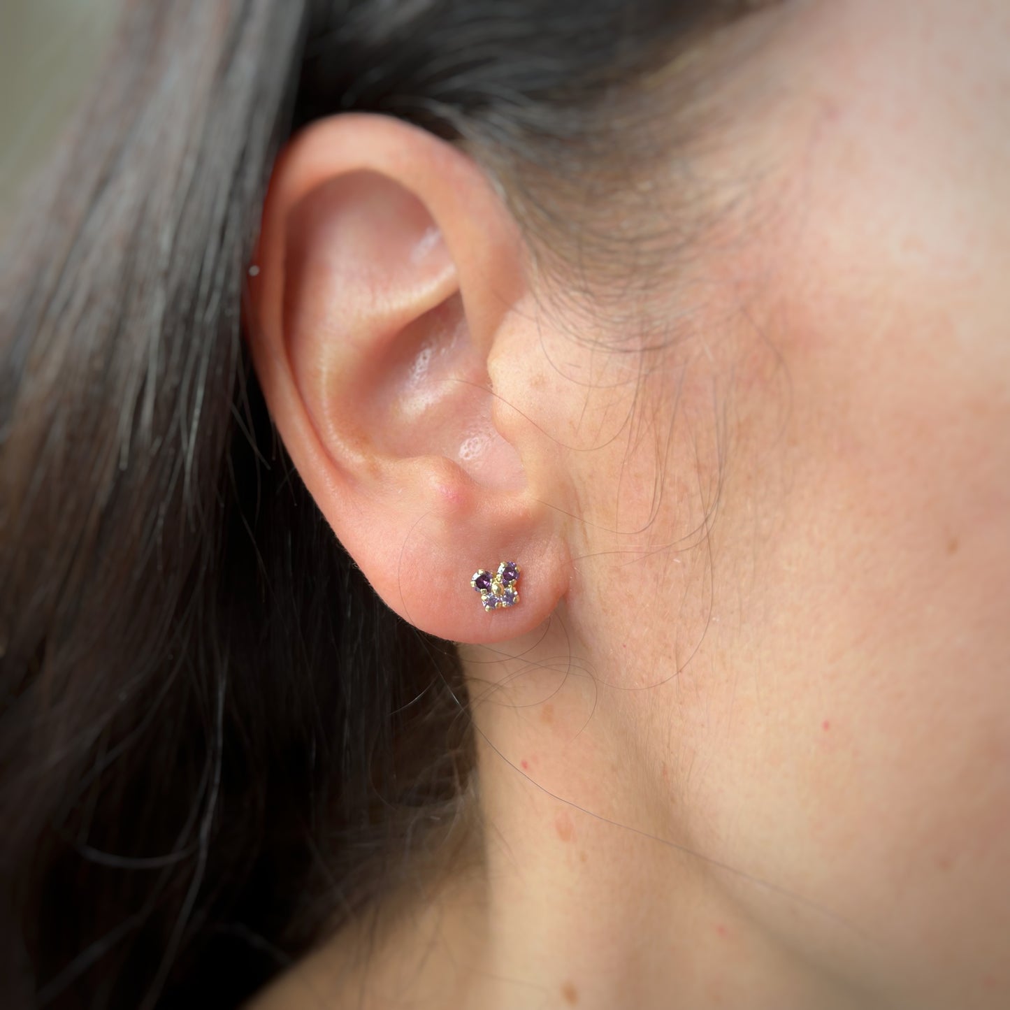 Aretes en oro amarillo 14k con mariposita de circonitas moradas con broche rosca