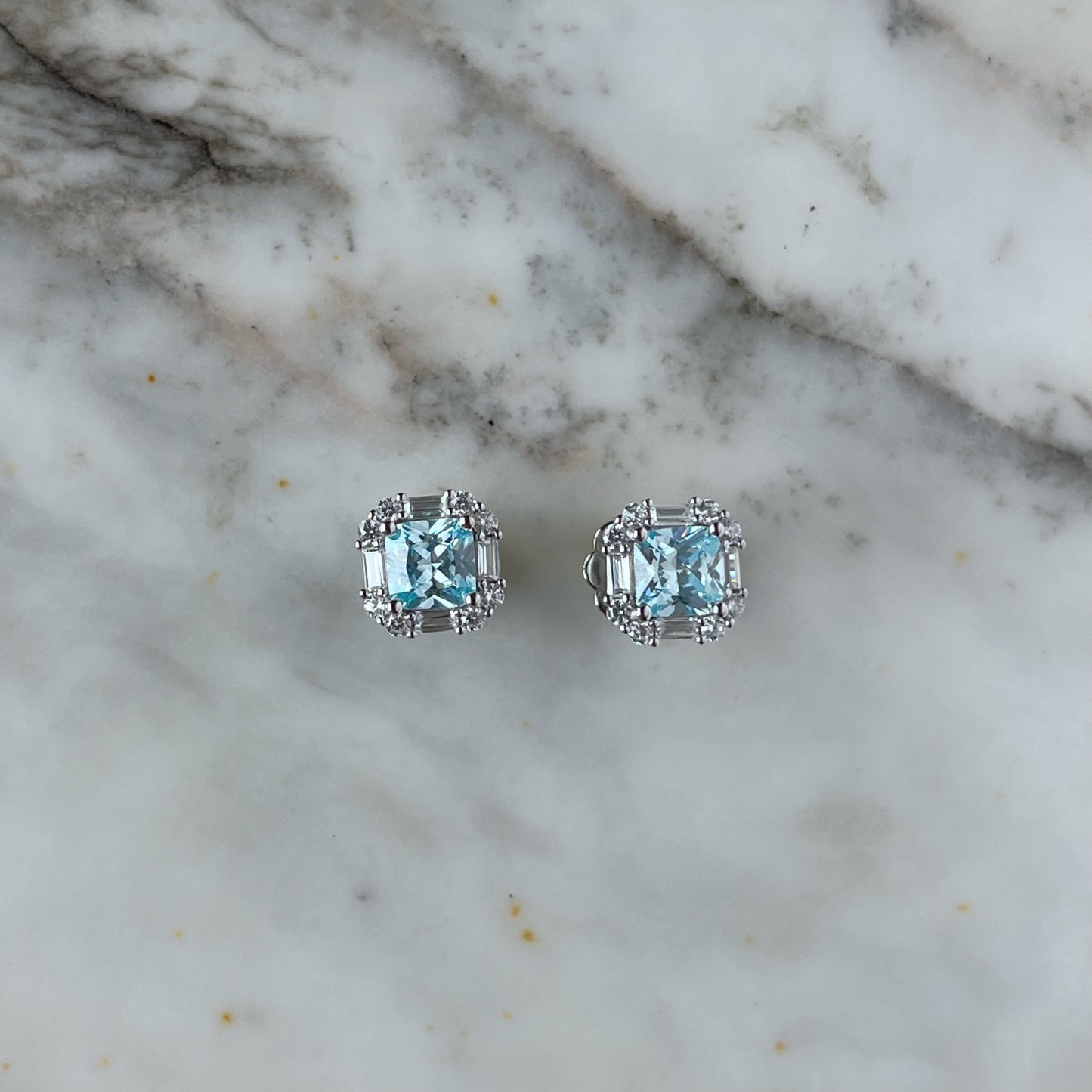 Arete de plata con baño platino cuadrado y circonita aquamarina con halo de circonitas blancas