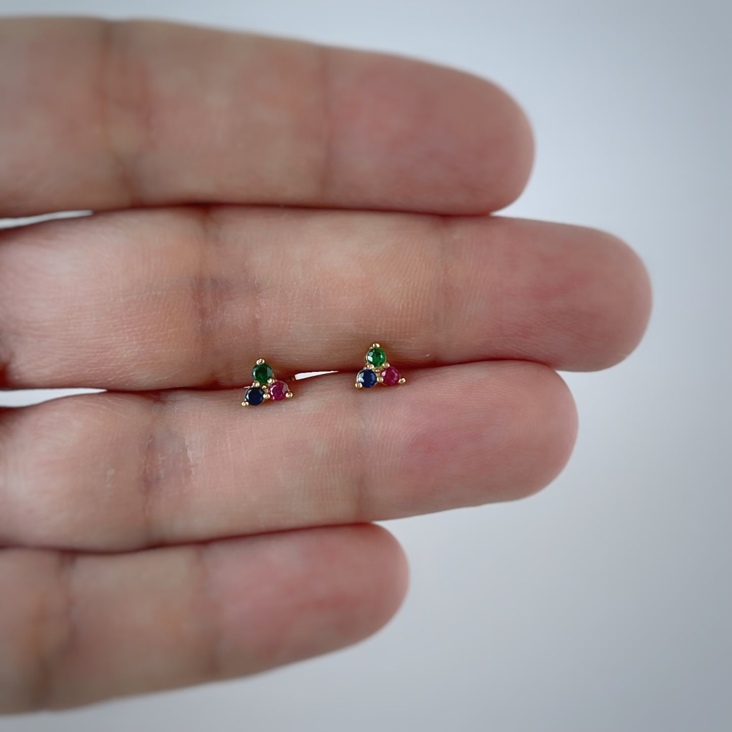 Aretes tres circonitas de color fucsia, azul y verde en oro amarillo de 14k con tope rosca