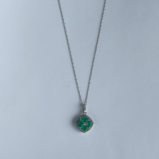 Collar en oro blanco 14k con dije de esmeraldas en forma de flor y borde de diamantes 0.15ctw