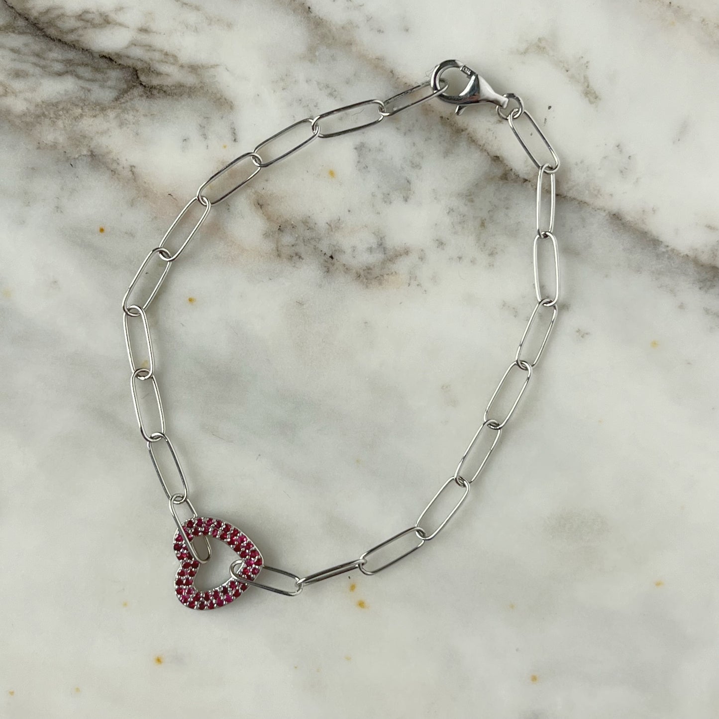 Pulsera paperclip en oro blanco 18K con dije de corazón y rubíes 0.24ctw