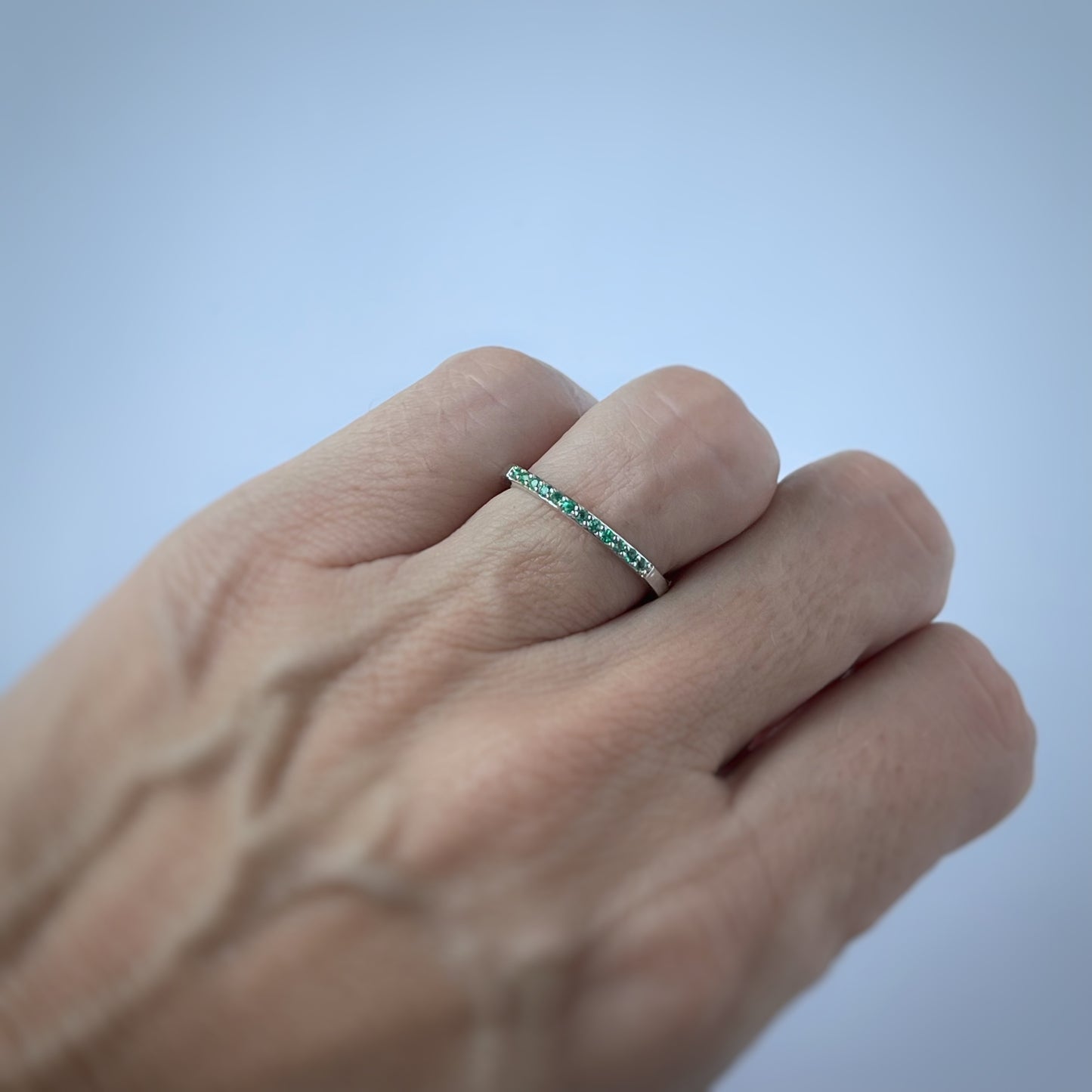 Anillo medio cintillo en oro blanco 14k con esmeraldas