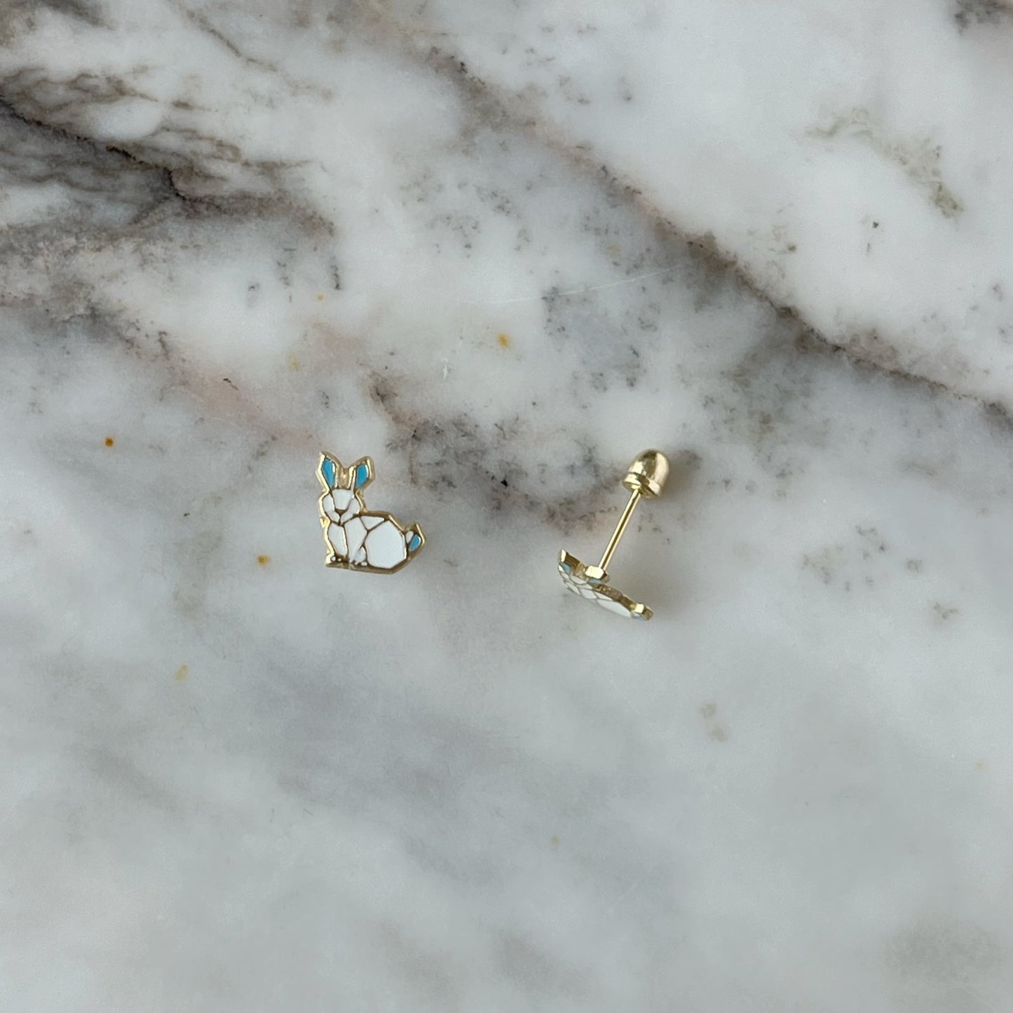 Aretes en oro amarillo 14K con conejo esmaltado blanco y orejas celestes con tope rosca