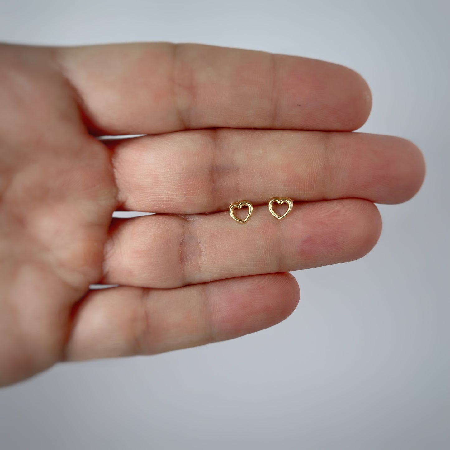 Aretes en oro amarillo 14k con corazón delineado con broche rosca