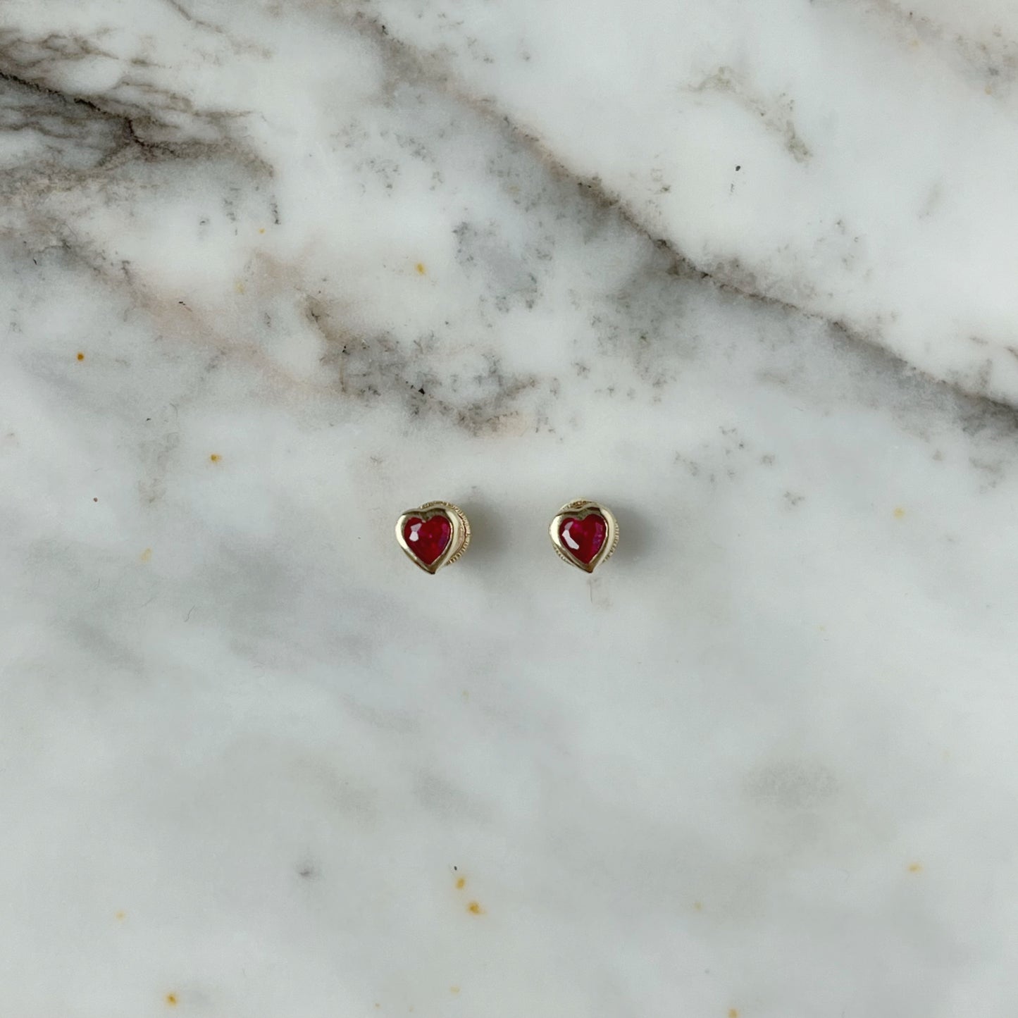 Aretes en oro amarillo 14k circonita roja de corazón con bisel con broche rosca