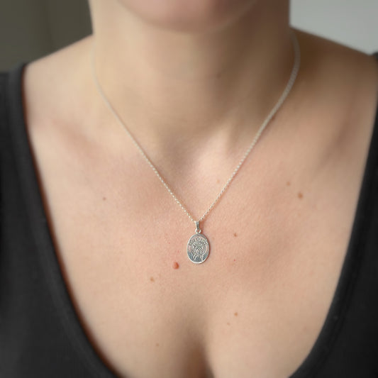 Dije escapulario ovalado en plata con la virgen de un lado y sagrado corazón del otro