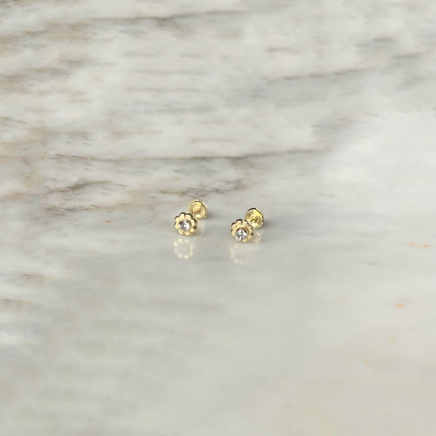Aretes en oro amarillo 14k de flor mini con circón en el centro con broche rosca