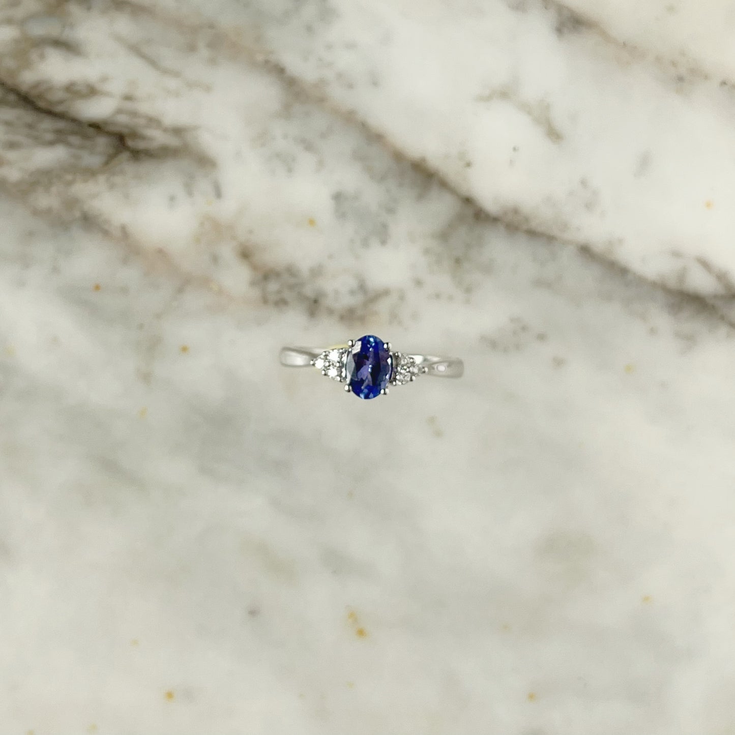 Anillo en oro blanco 10k con tanzanita ovalada y diamantes 0.10ctw