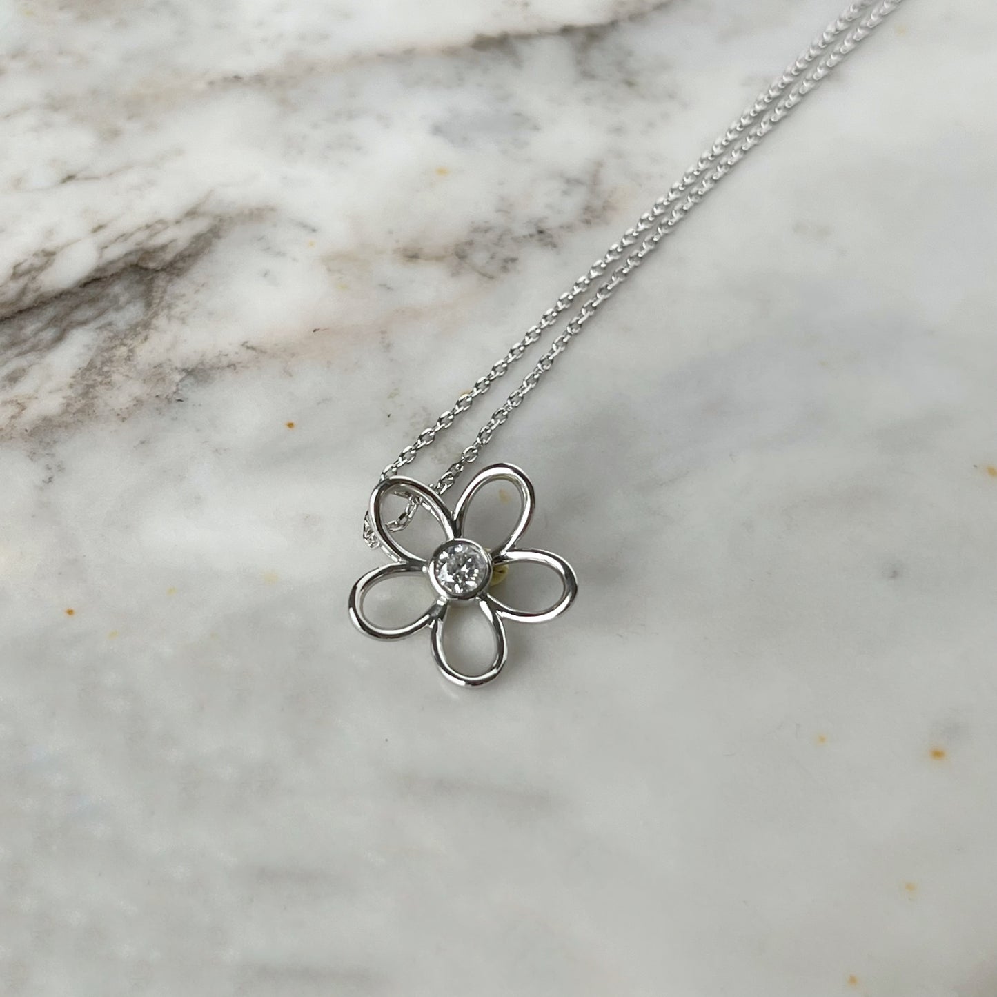 Collar en plata con dije de flor delineada y diamante central 0.10ct