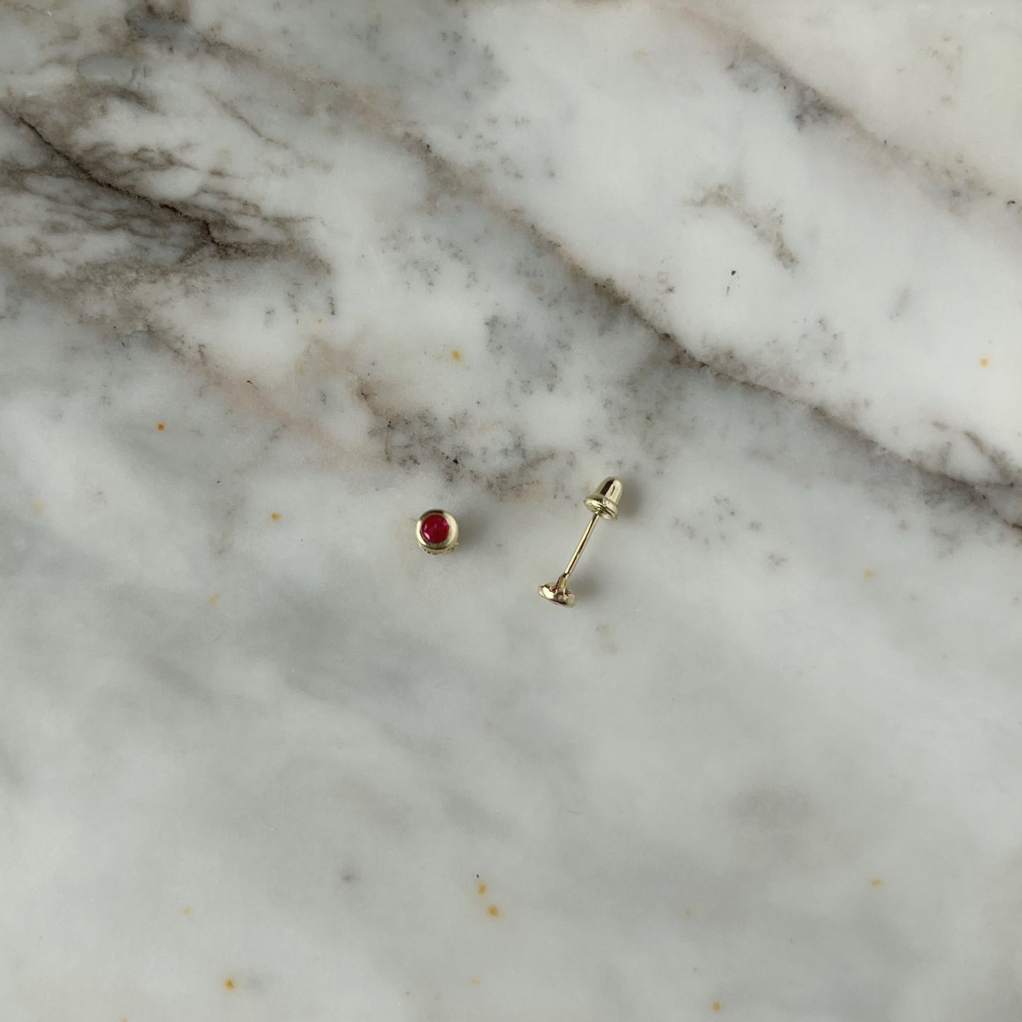 Aretes en oro amarillo 14k con circón biselado rojo con broche rosca