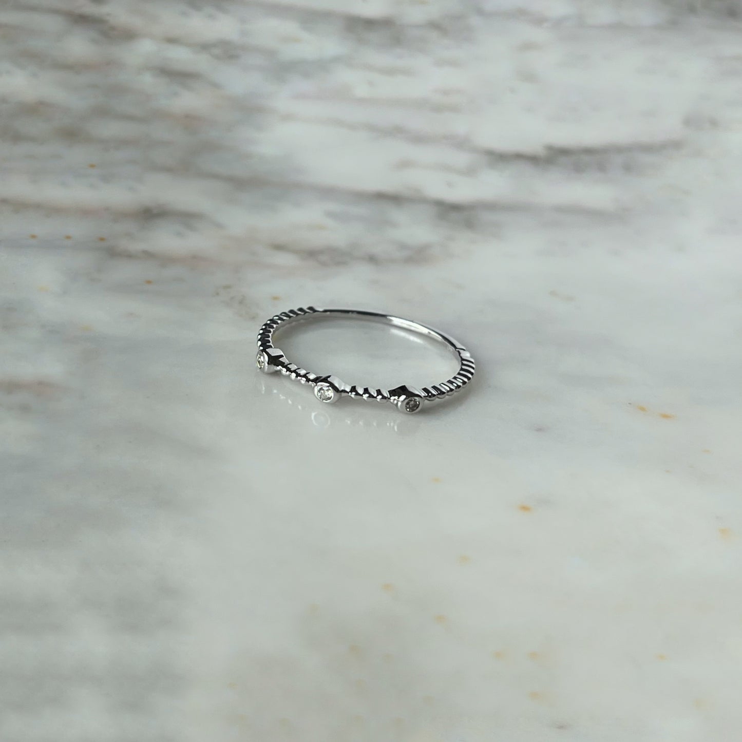 Anillo en oro blanco 14k de bolitas con 3 diamantes