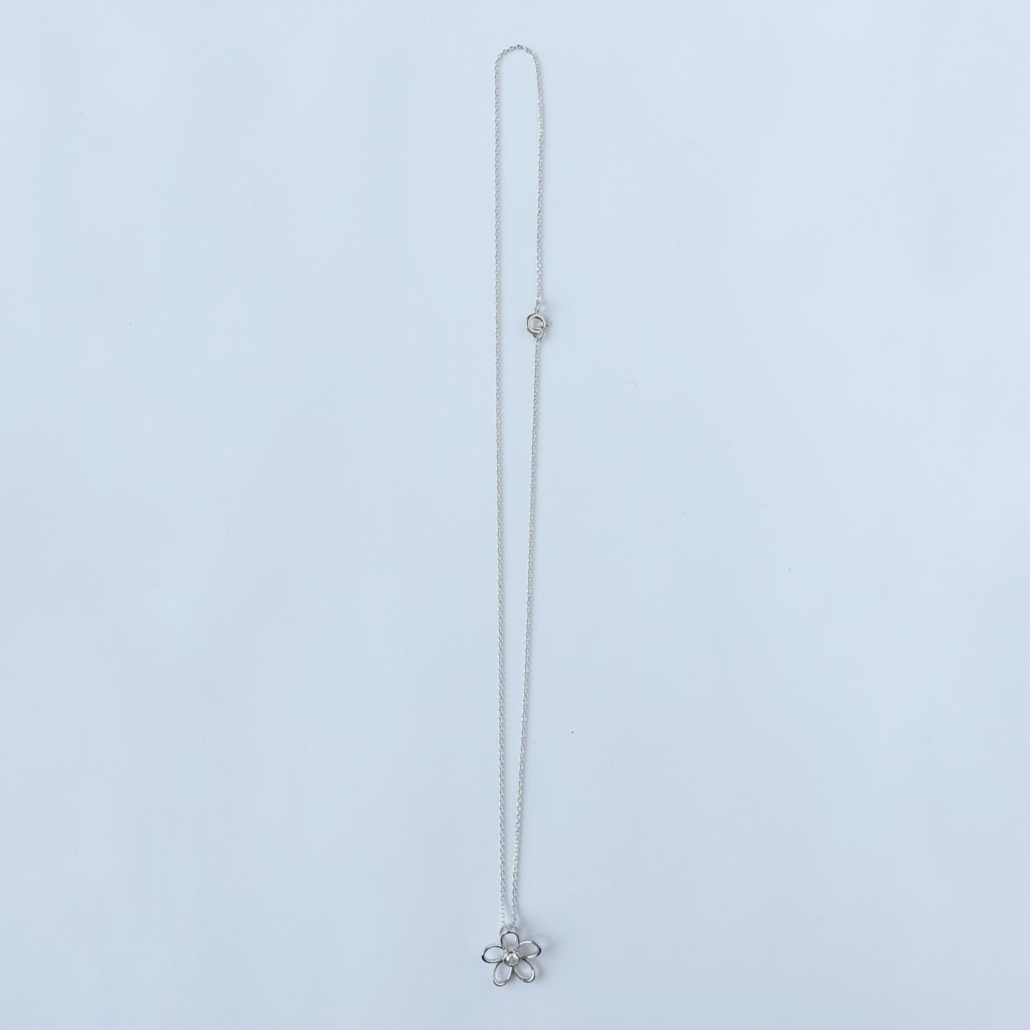 Collar en plata con dije de flor delineada y diamante central 0.10ct