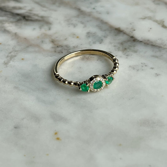 Anillo en oro amarillo 14k con tres esmeraldas redondas 0.25ctw y diamantes 0.04ct con aro de bolitas