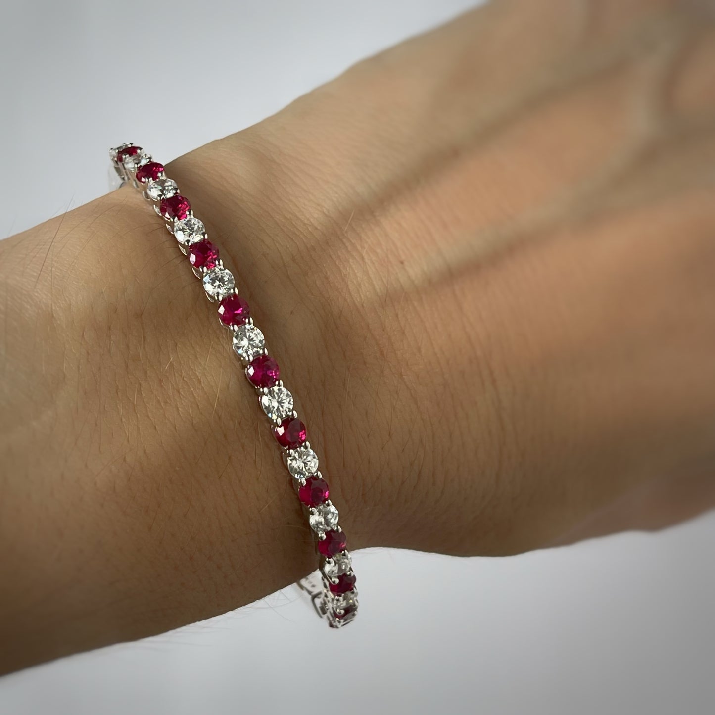 Pulsera dura de plata con baño platino y circonita blancas y rojo rubí