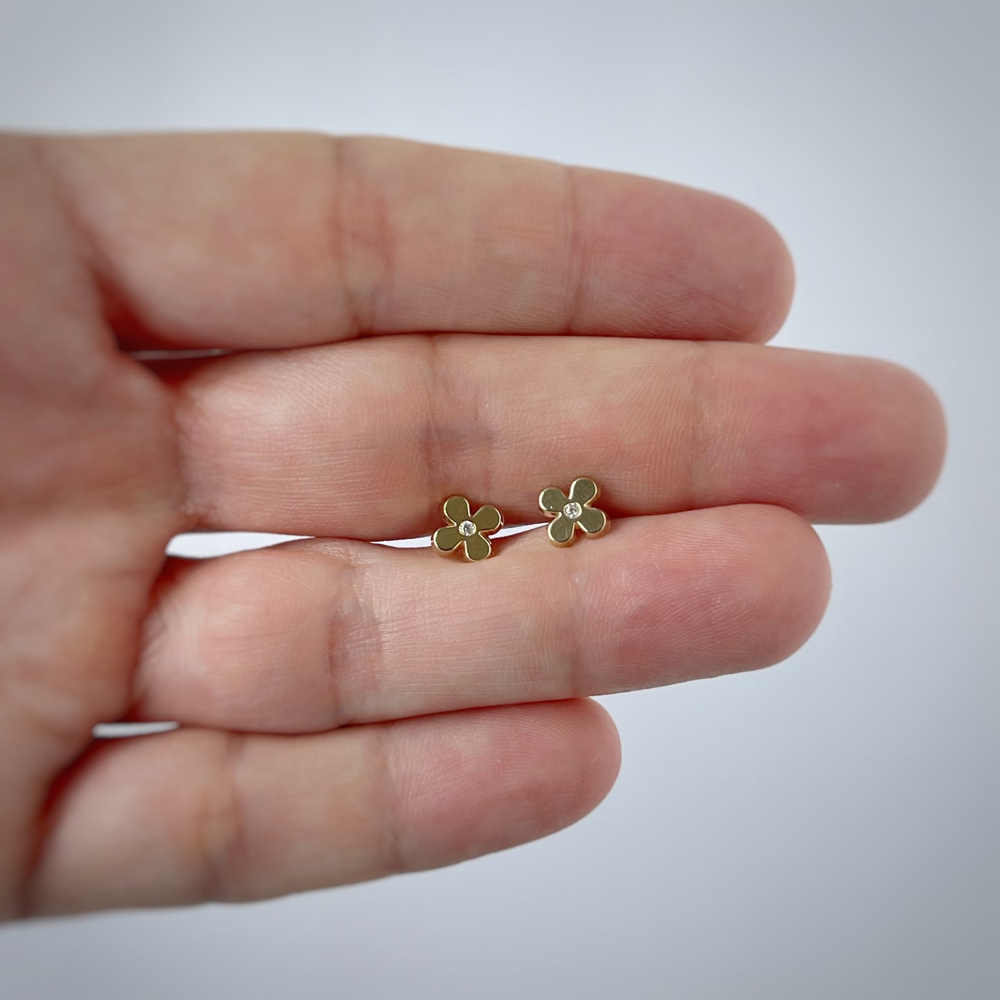 Aretes en oro amarillo de 14k con flor y circonita en el centro con broche rosca