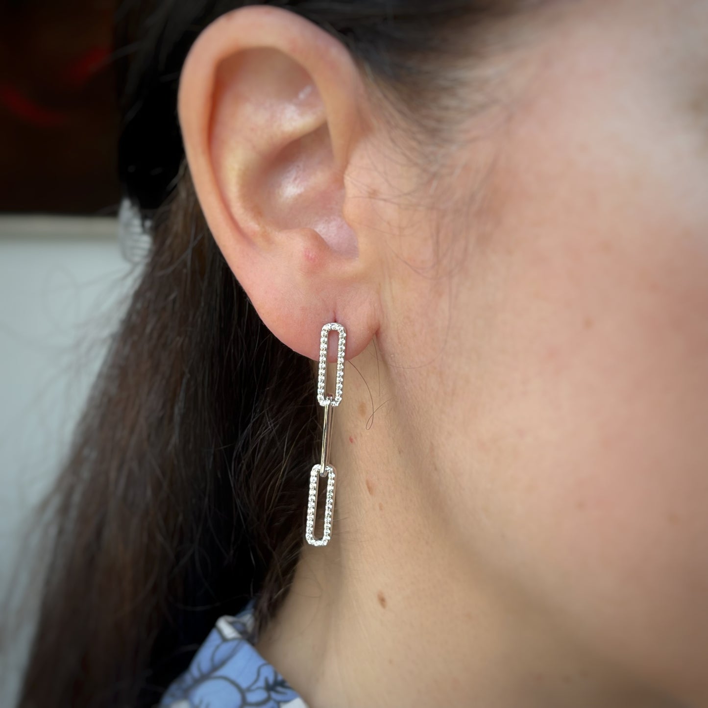 Arete largo paper clip de plata con baño platino y circonitas blancas