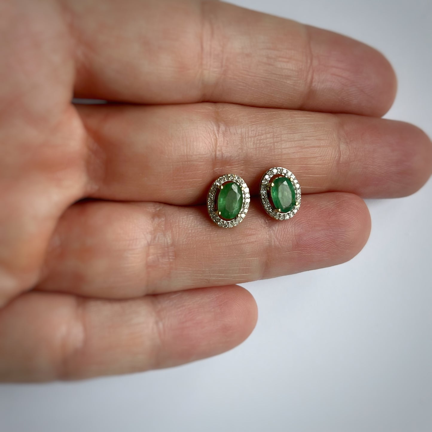 Aretes en oro amarillo 10k con esmeralda ovalada y halo de diamantes 0.15ctw