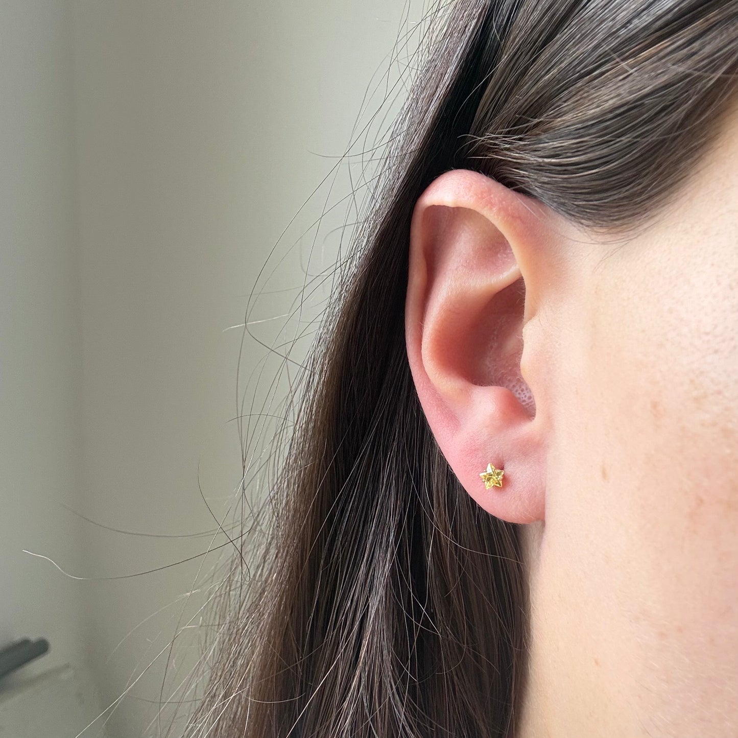Aretes mini estrella con circón amarillo en oro amarillo 14K con tope rosca