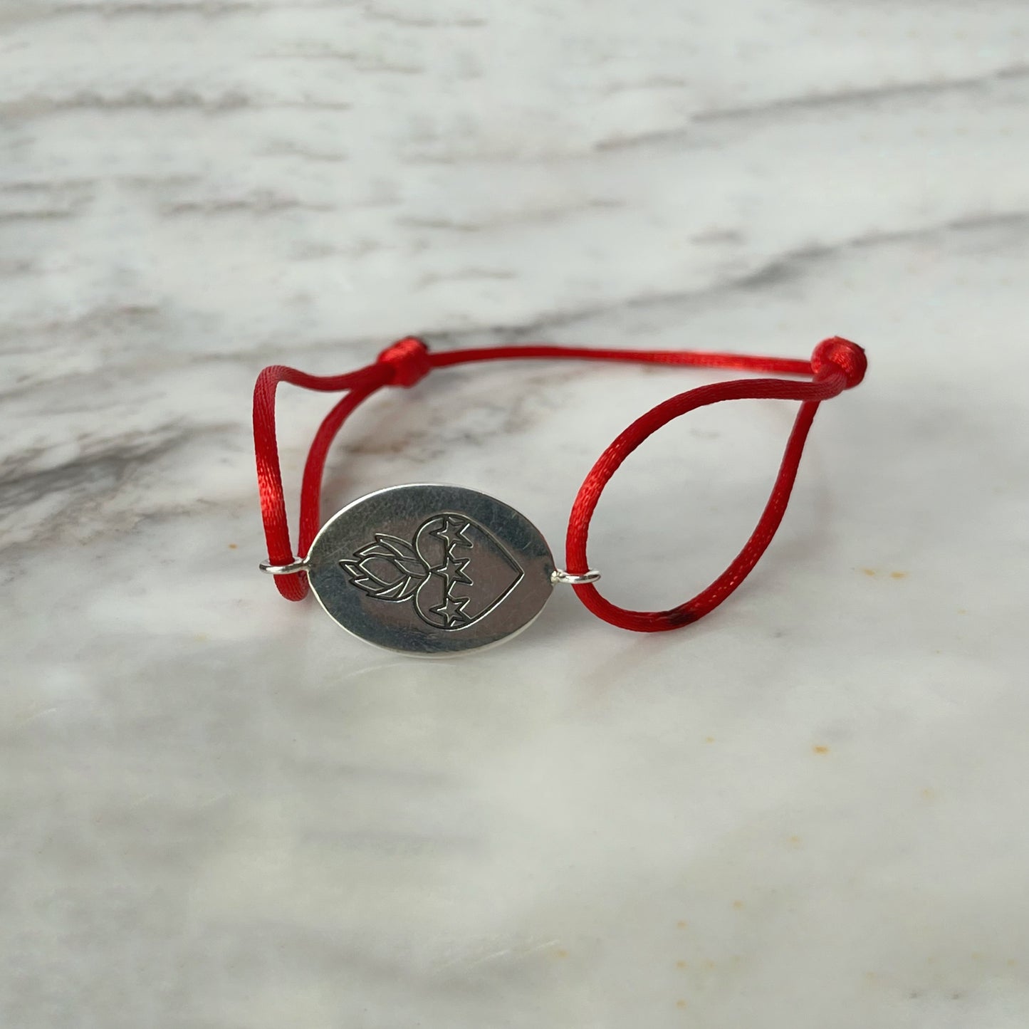 Pulsera de cordón con escapulario ovalado en plata