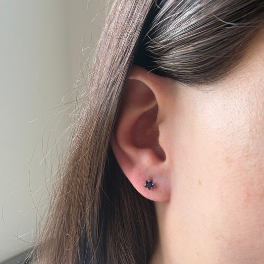 Aretes mini estrella con circón azul en oro amarillo 14K con tope rosca.