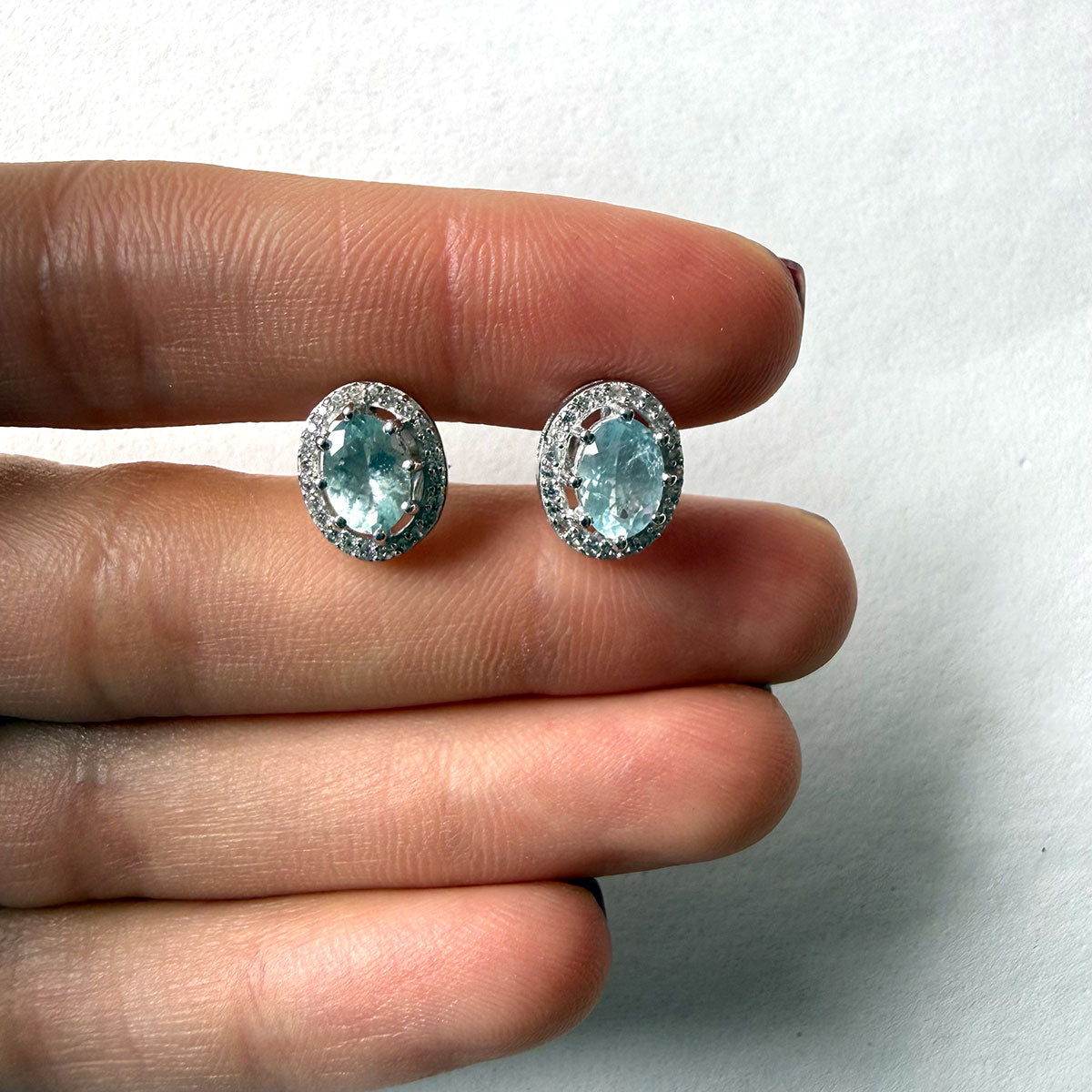 Aretes de plata con aquamarina ovalada y halo de circones