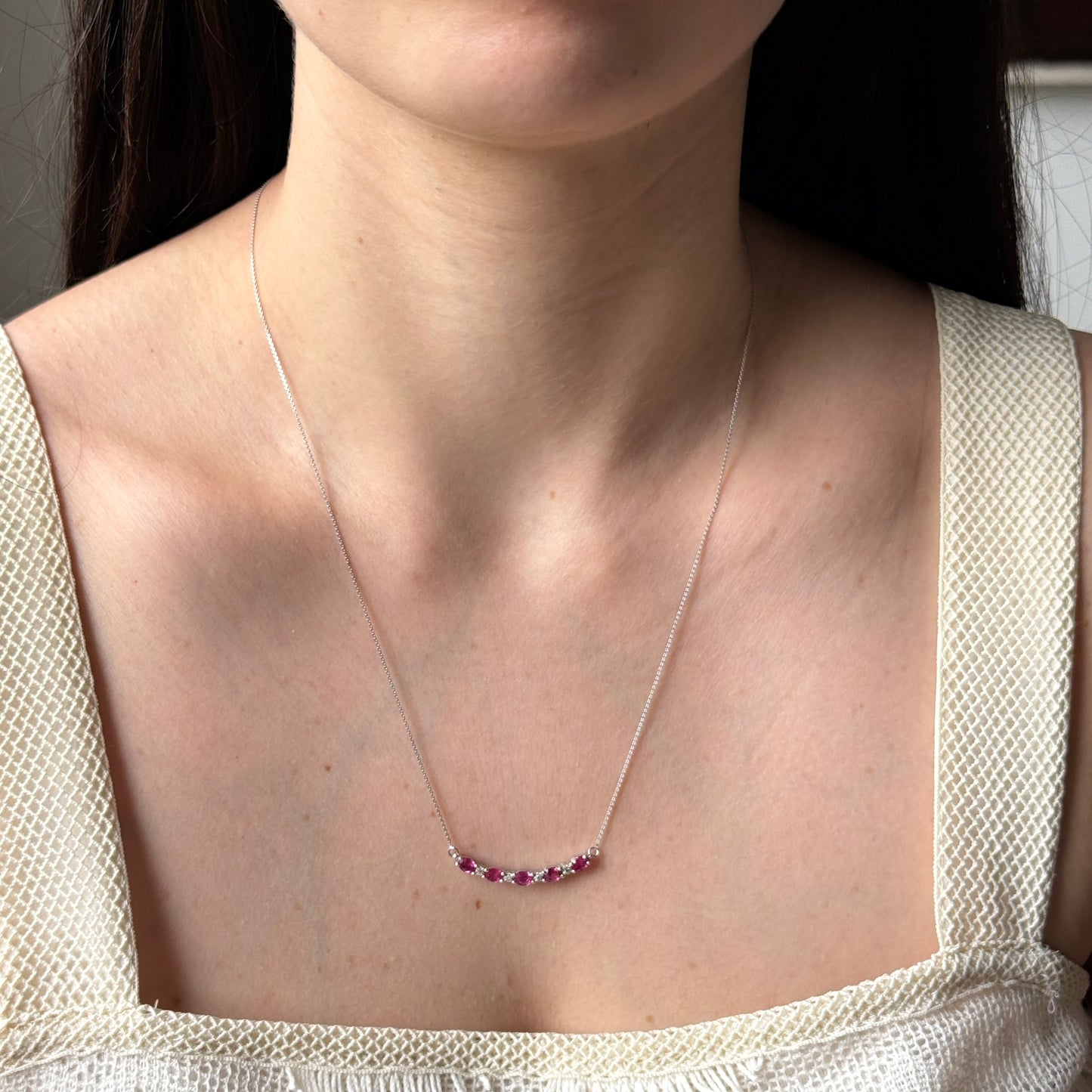 Collar en oro blanco 10k con curva de rubíes y diamantes