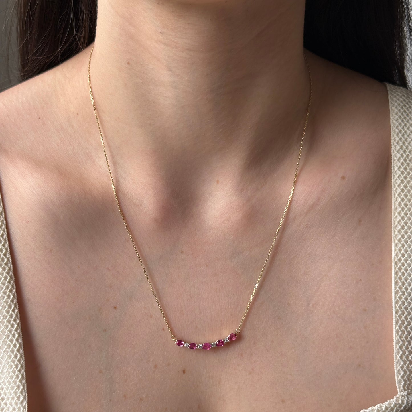 Collar en oro amarillo 10k con curva de rubíes y diamantes