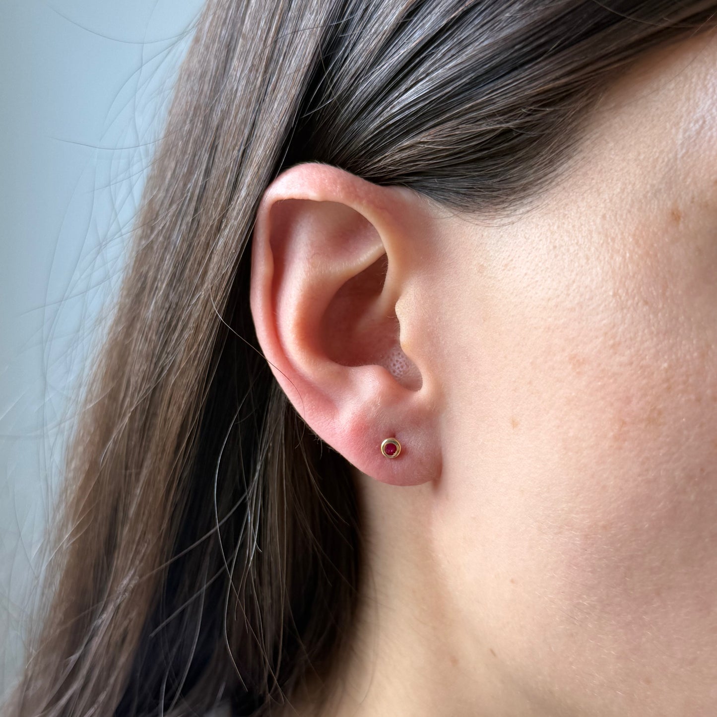 Aretes en oro amarillo 14k con circón fucsia biselado borde grueso con tope rosca