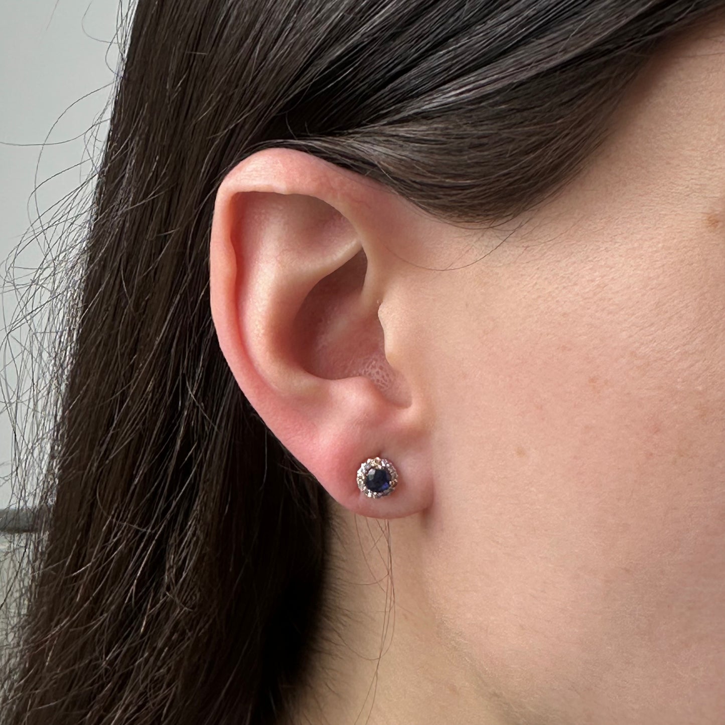 Aretes redondos en oro blanco 10k con zafiros y halo de diamantes 0.10ctw