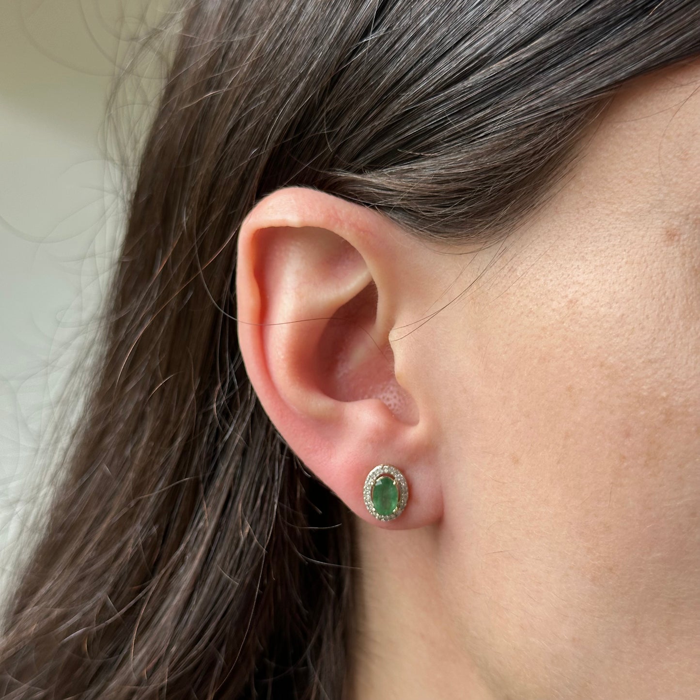 Aretes en oro amarillo 10k con esmeralda ovalada y halo de diamantes 0.15ctw