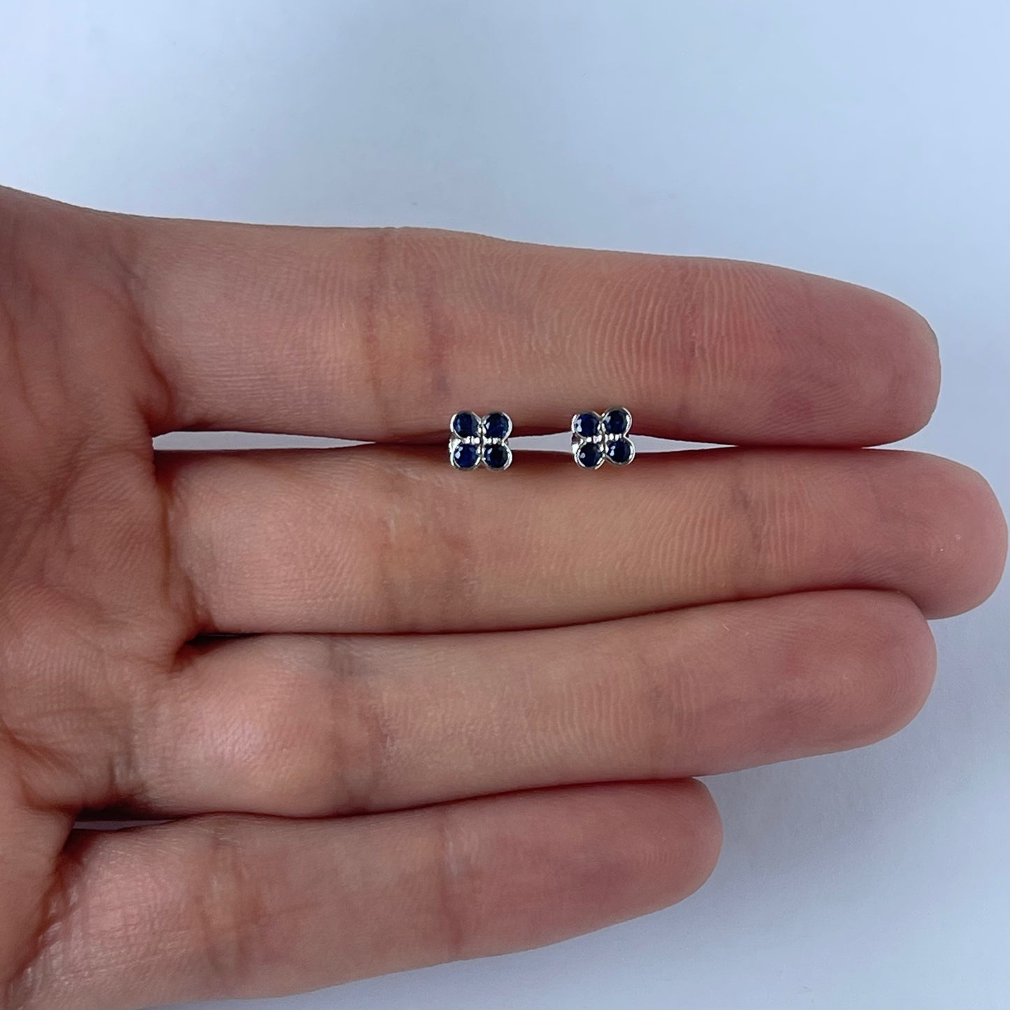 Aretes en oro blanco 10k con flor de zafiros y biseladas y broche a rosca