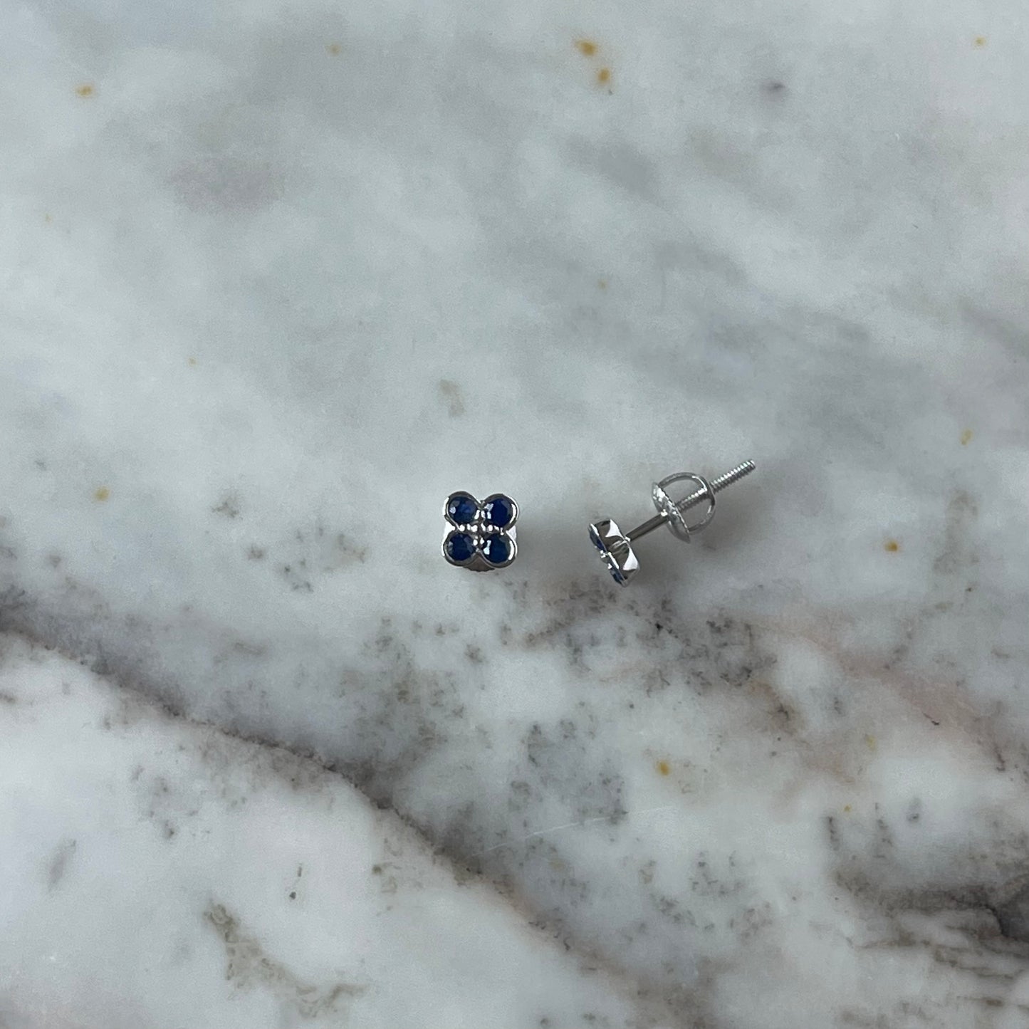 Aretes en oro blanco 10k con flor de zafiros y biseladas y broche a rosca