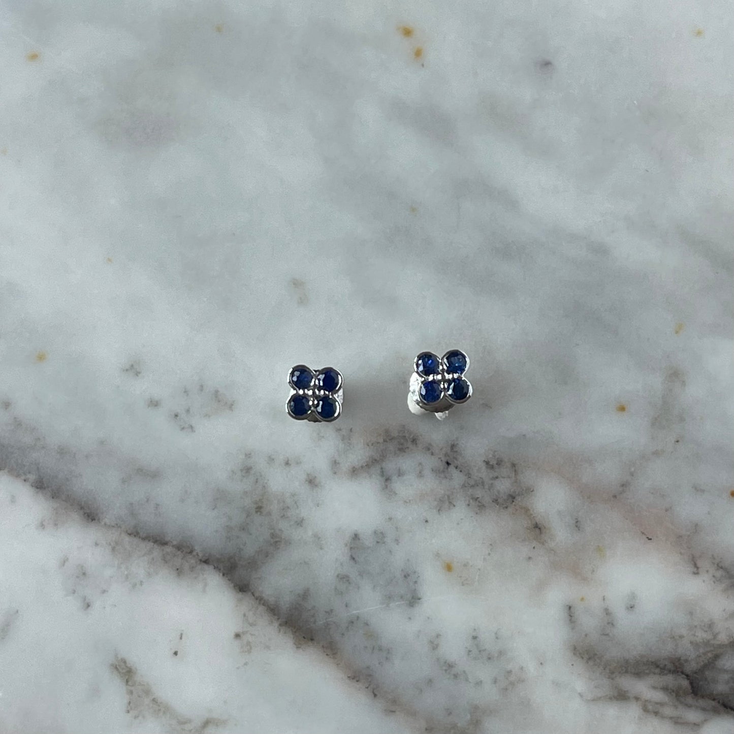 Aretes en oro blanco 10k con flor de zafiros y biseladas y broche a rosca