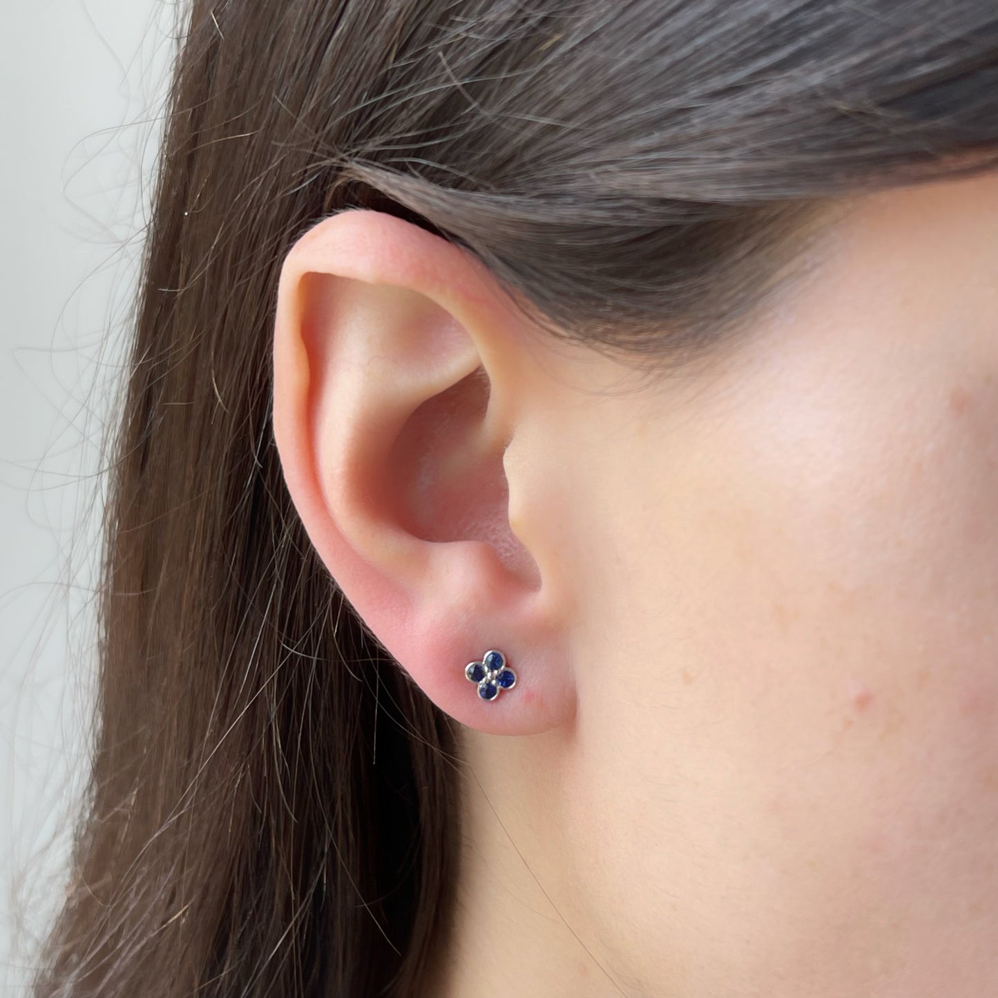 Aretes en oro blanco 10k con flor de zafiros y biseladas y broche a rosca