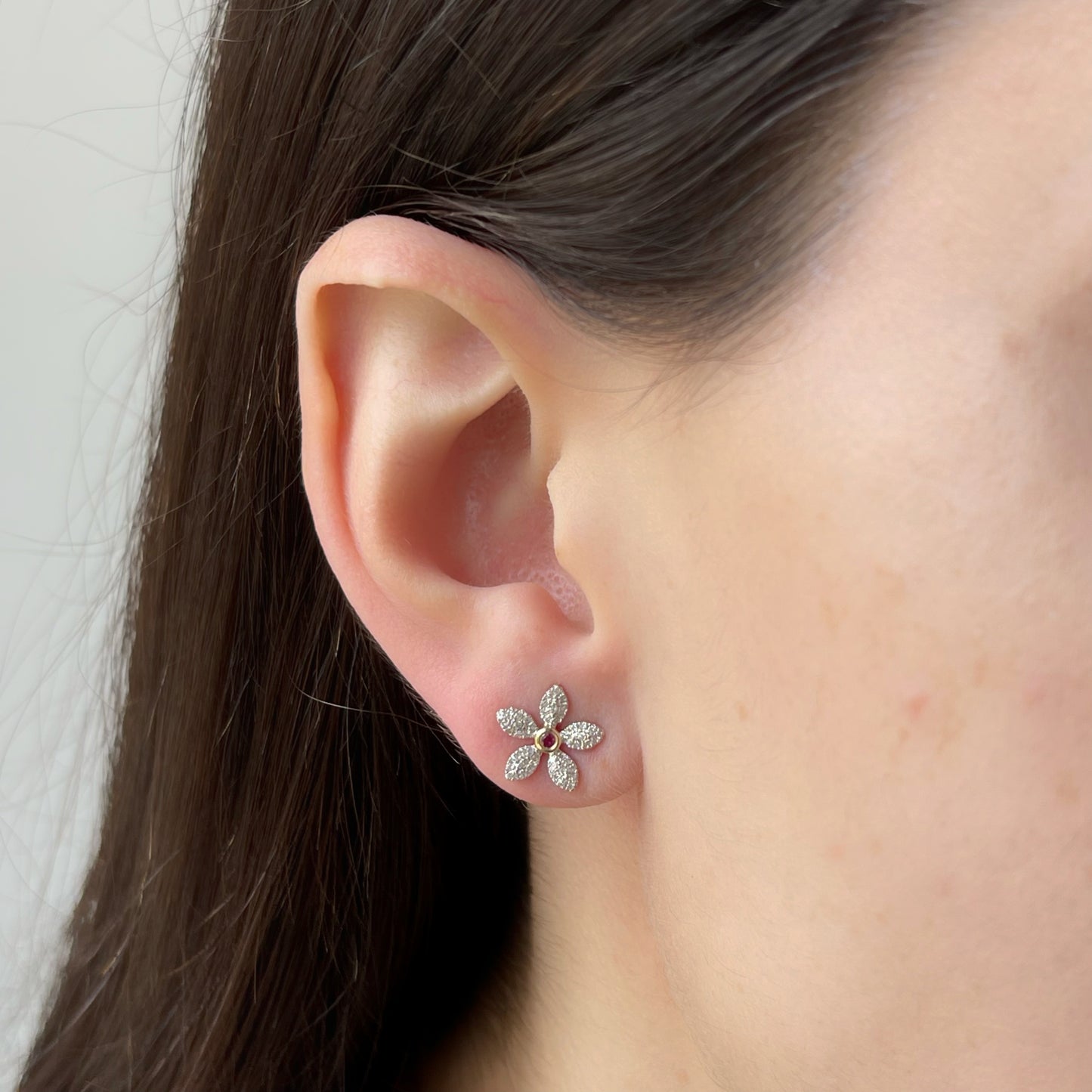 Aretes flor de diamantes 0.25ctw con centro de rubí en oro amarillo 10k con broche a rosca